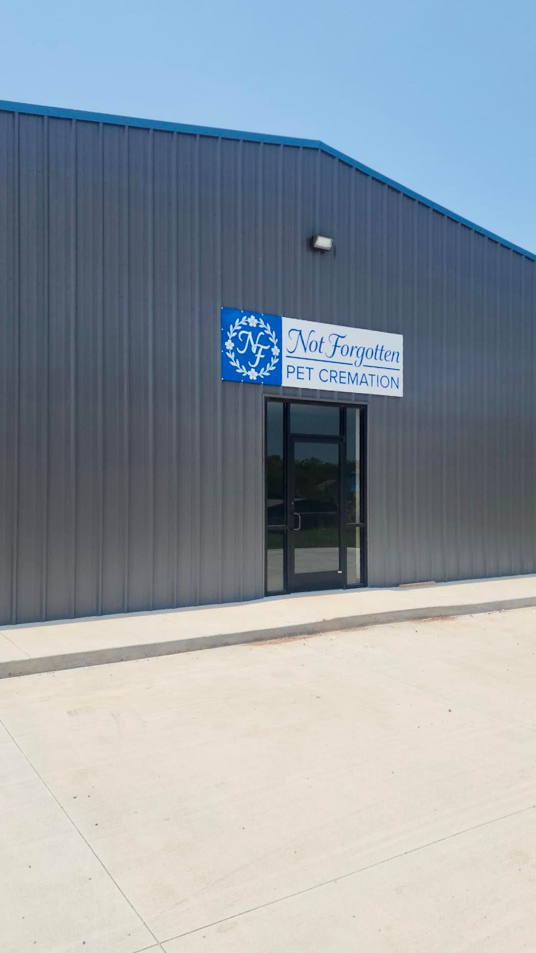 A large gray building with a blue sign on the side of it.