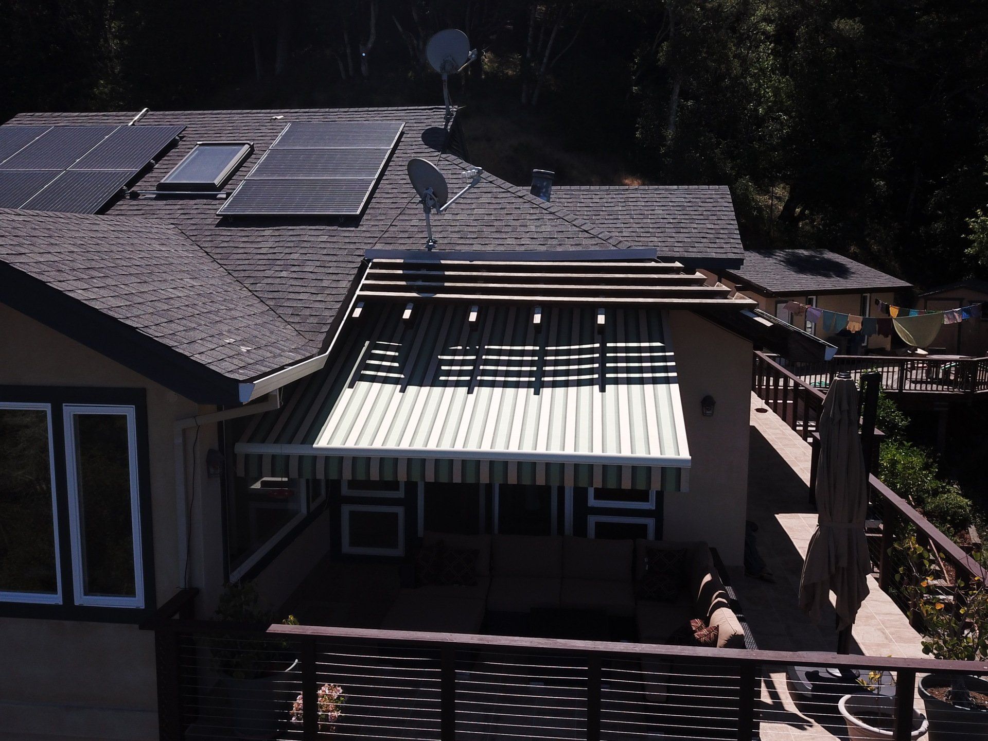 A house with a striped awning and solar panels on the roof