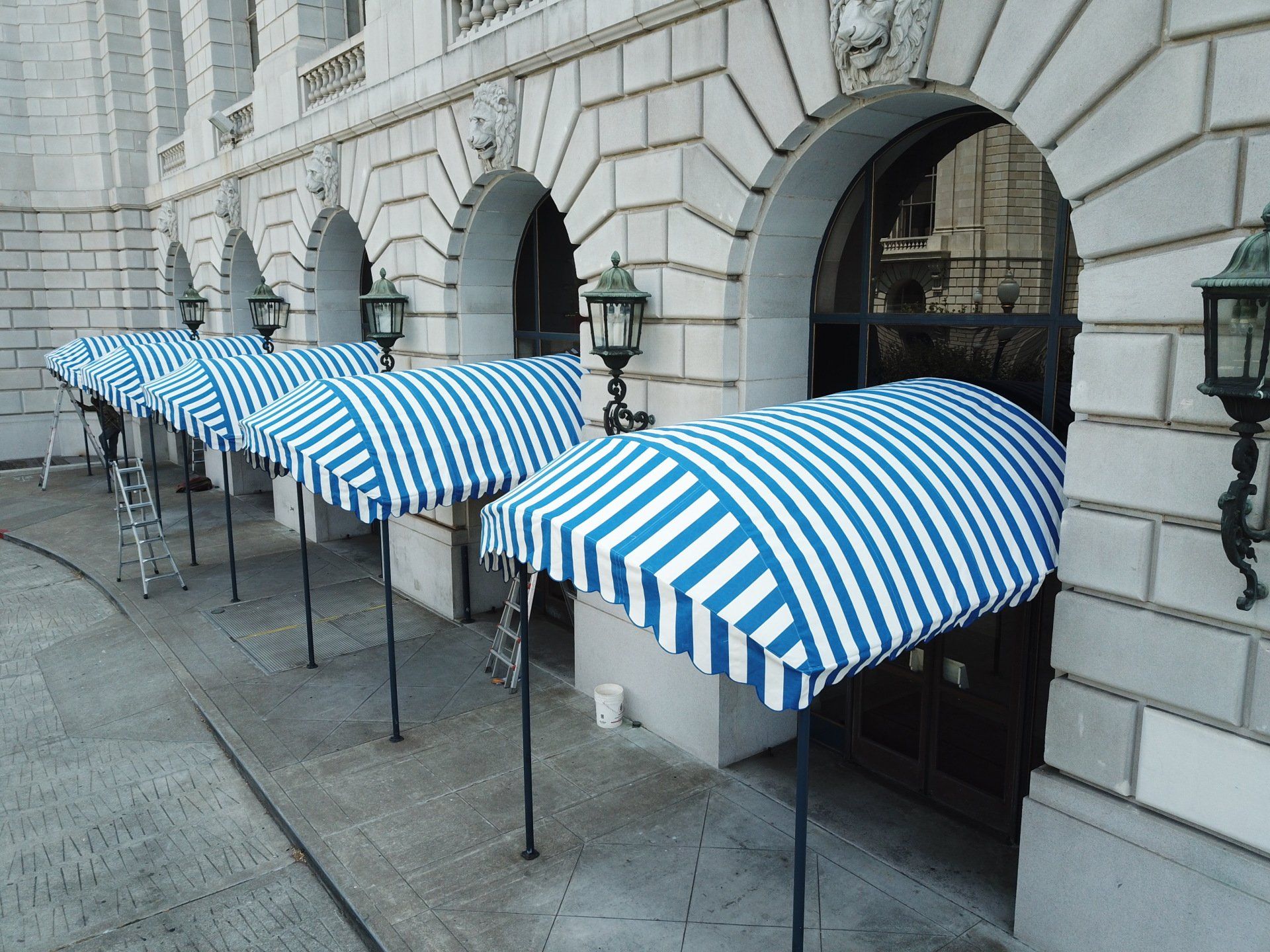 A row of blue and white striped awnings on the side of a building