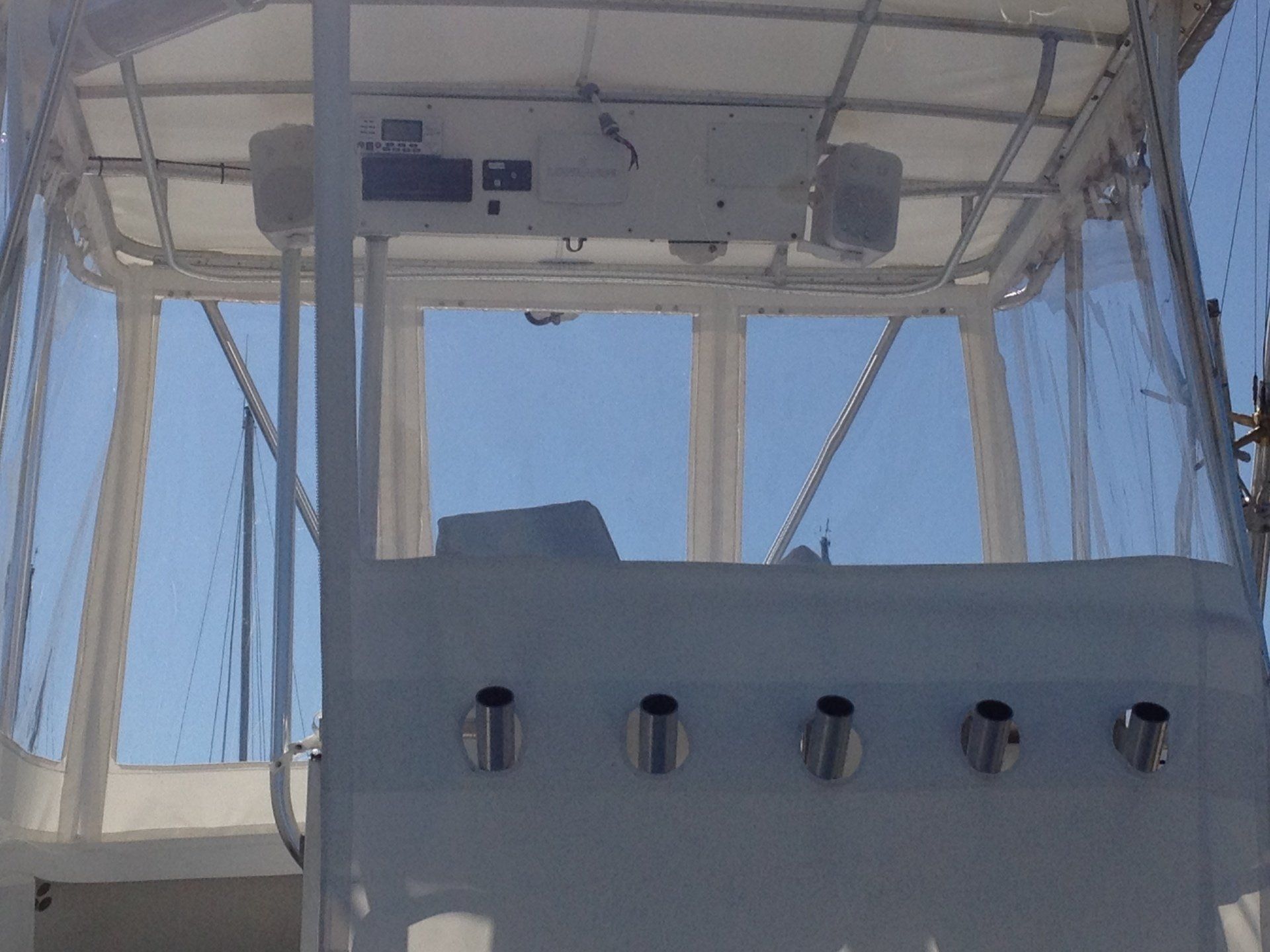The inside of a boat with a clear canopy and fishing poles.