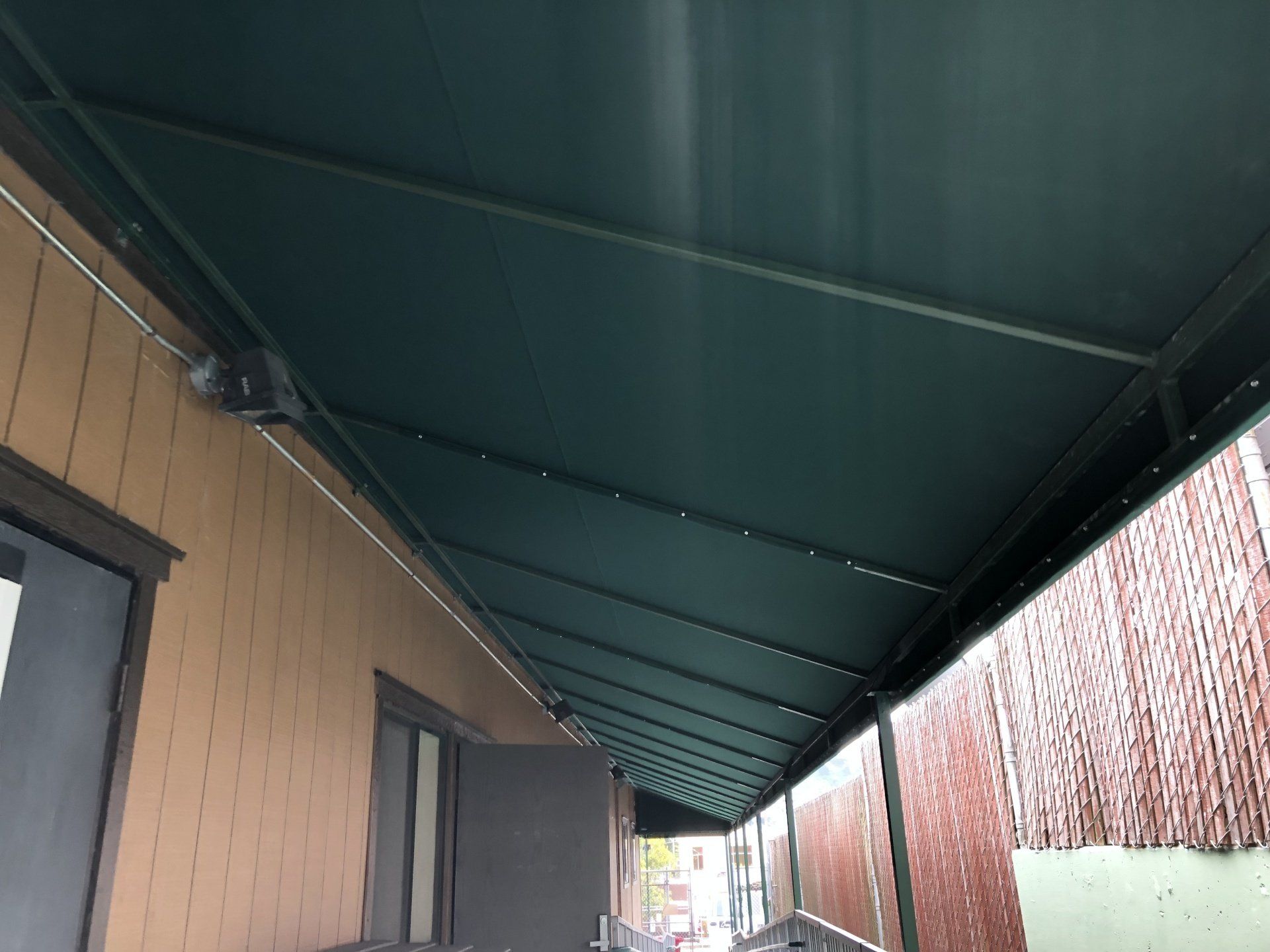 A green awning is on the side of a building.