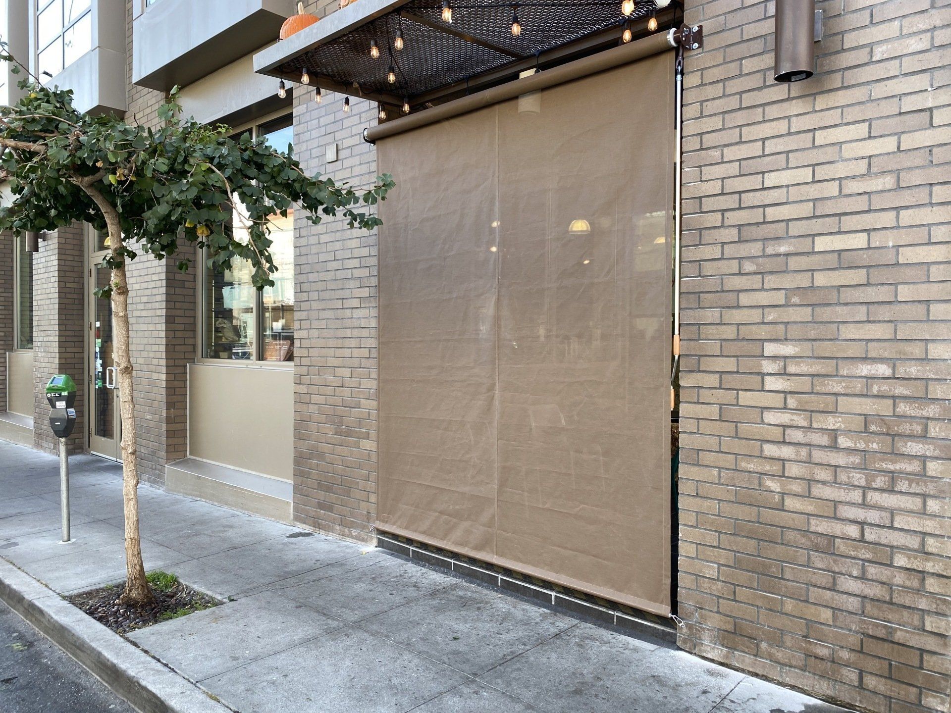 A brick building with a brown awning on the side of it