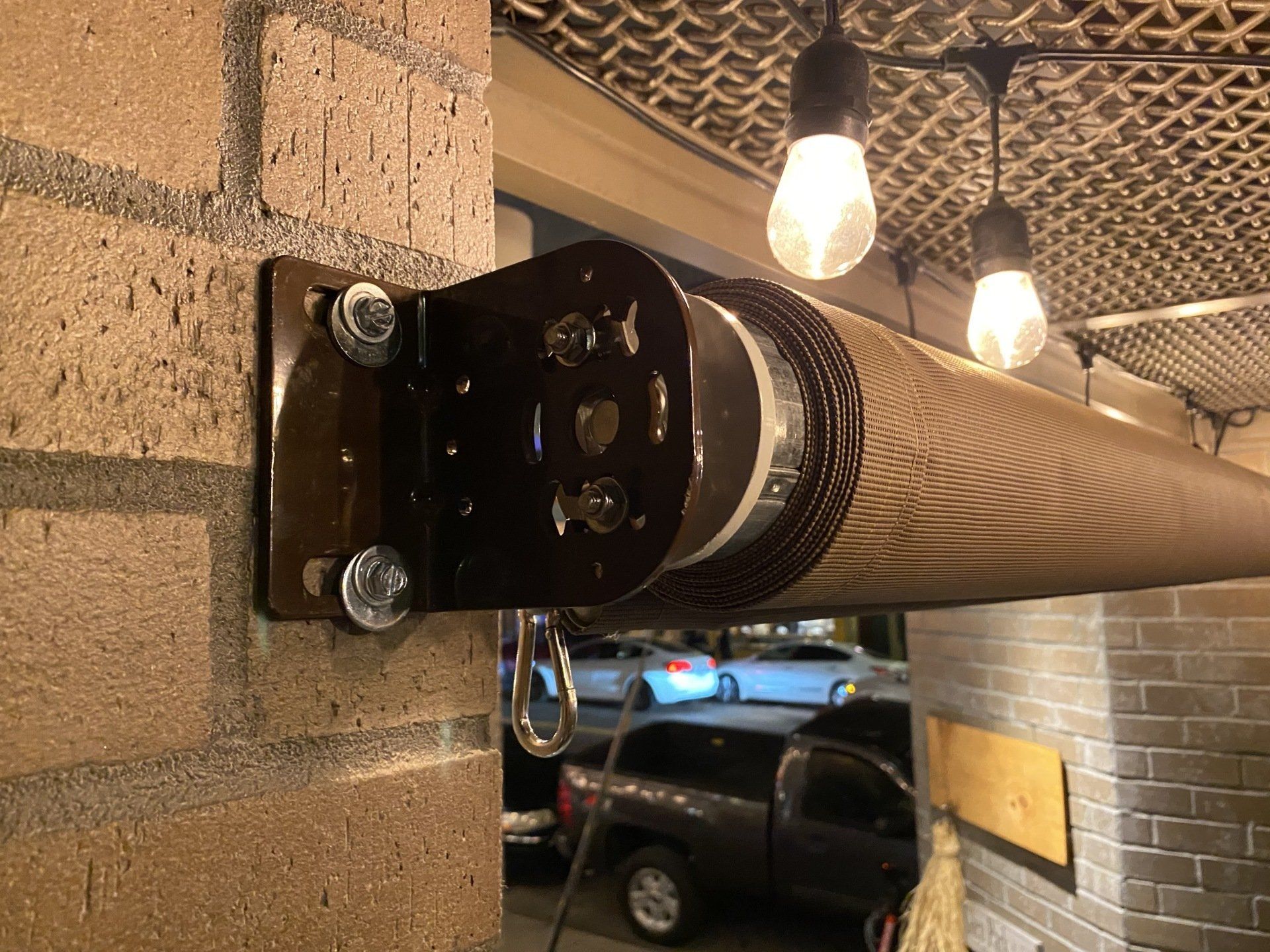 A car is parked in a garage next to a brick wall.