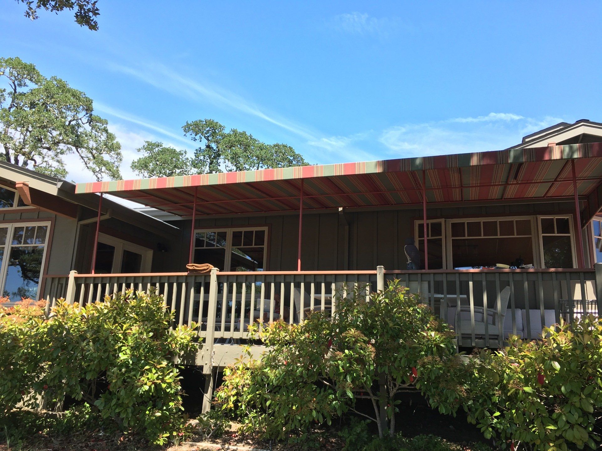 A house with a large deck and a canopy over it.