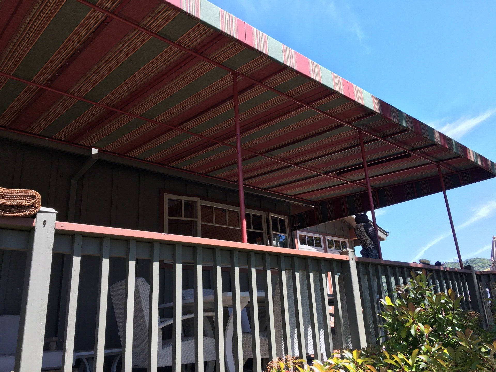 A deck with a striped awning over it