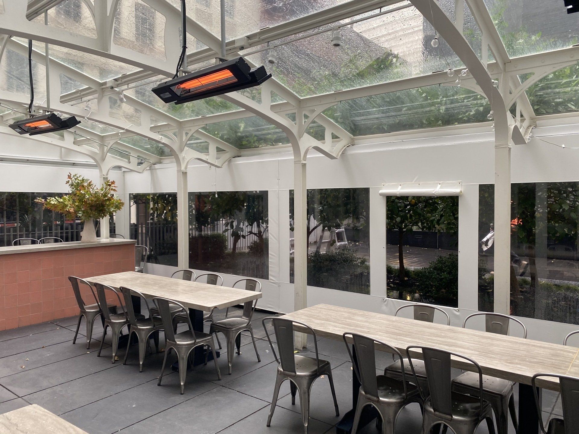 A large room with tables and chairs under a glass roof.