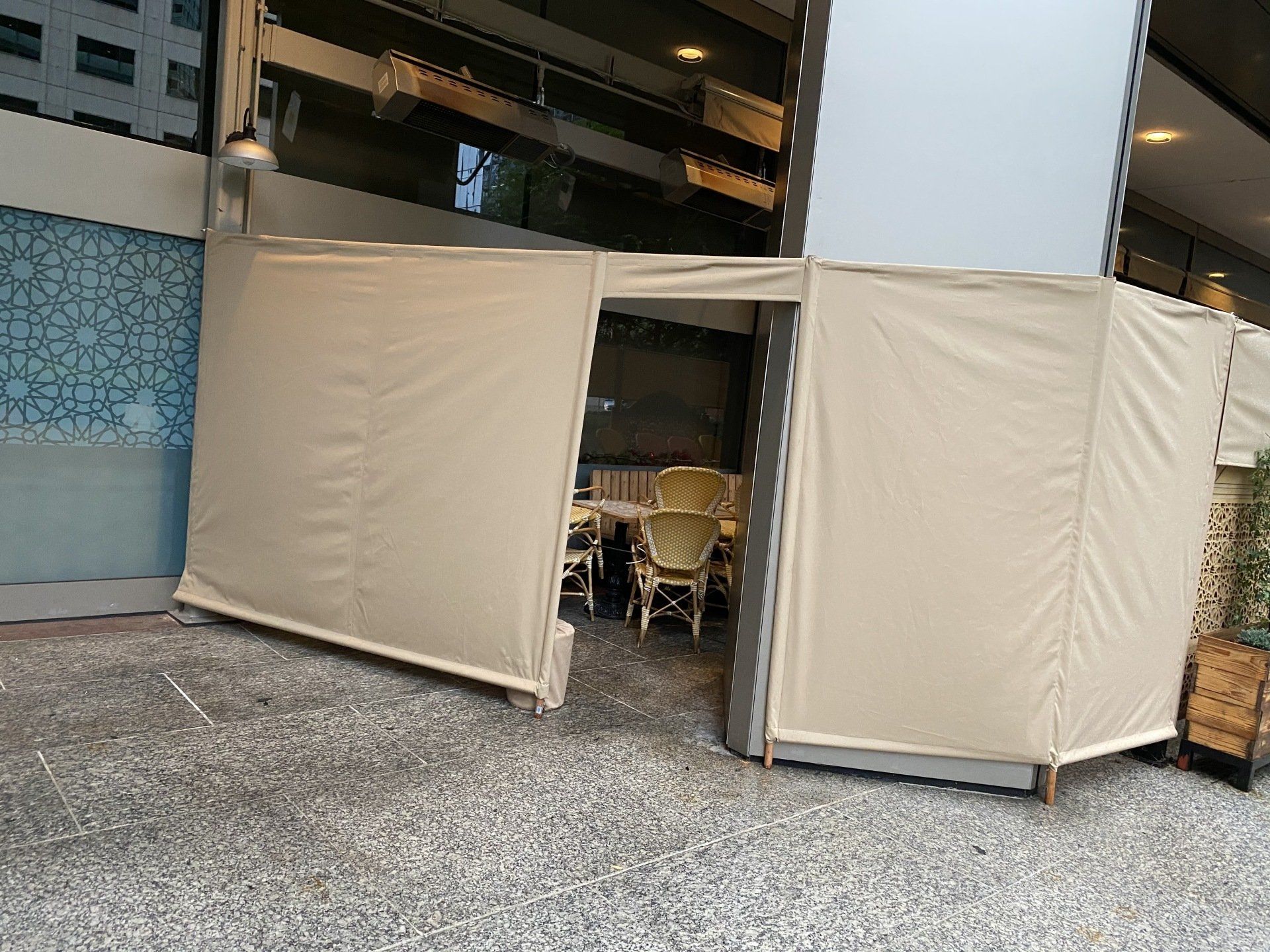 A tent is sitting on the ground in front of a building.