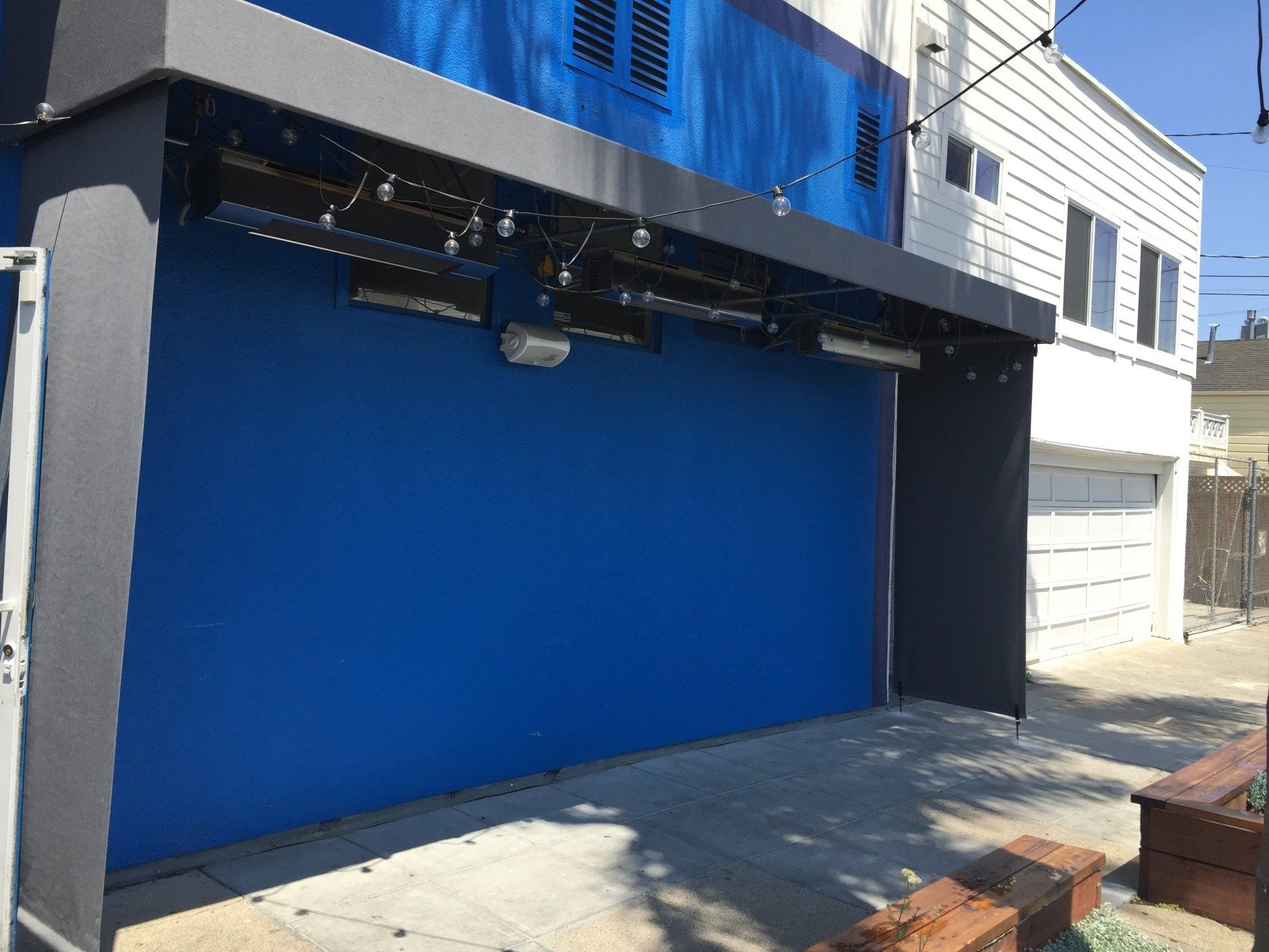 A blue garage door is on the side of a building.