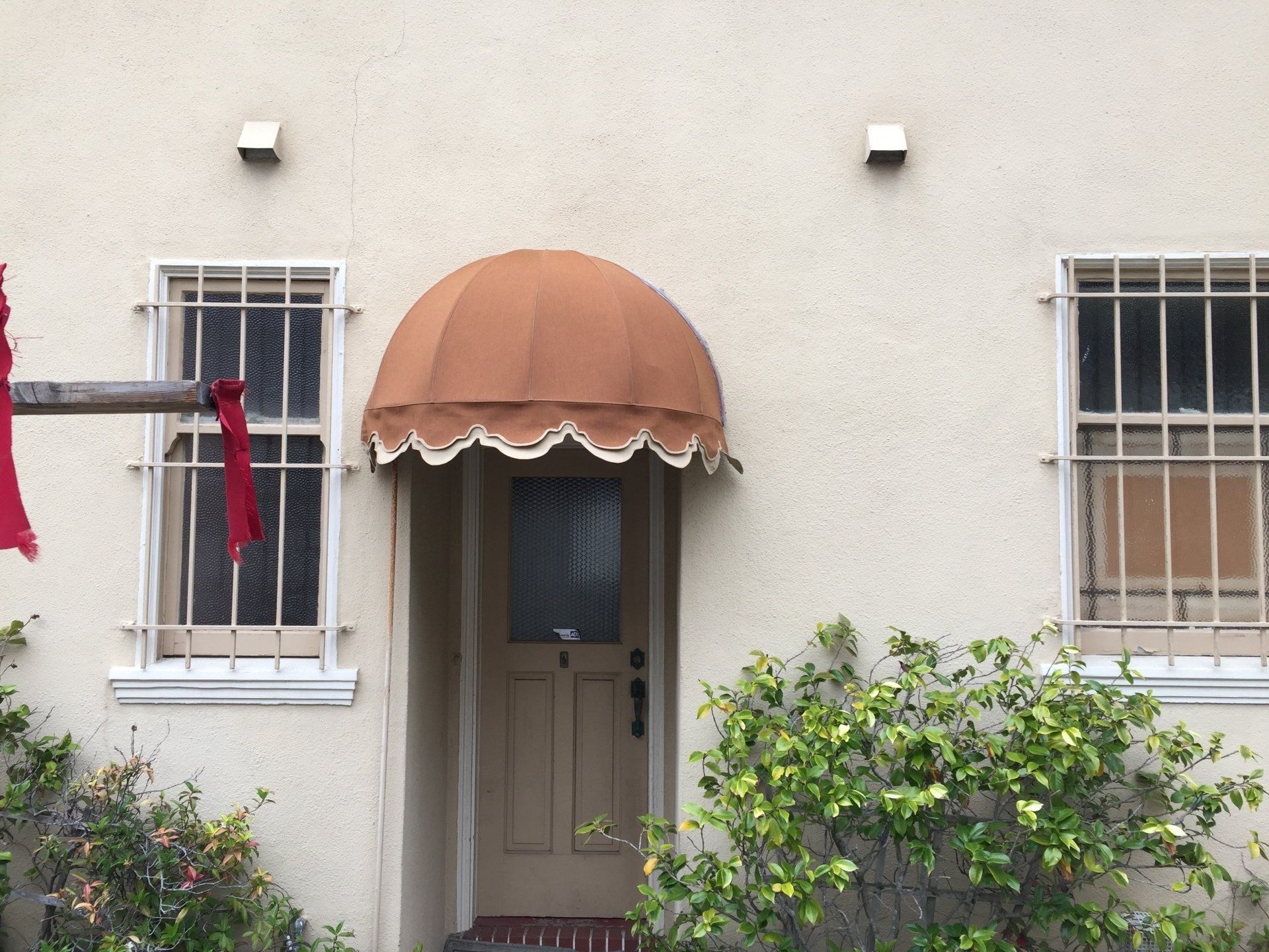 A white house with a brown awning over the door