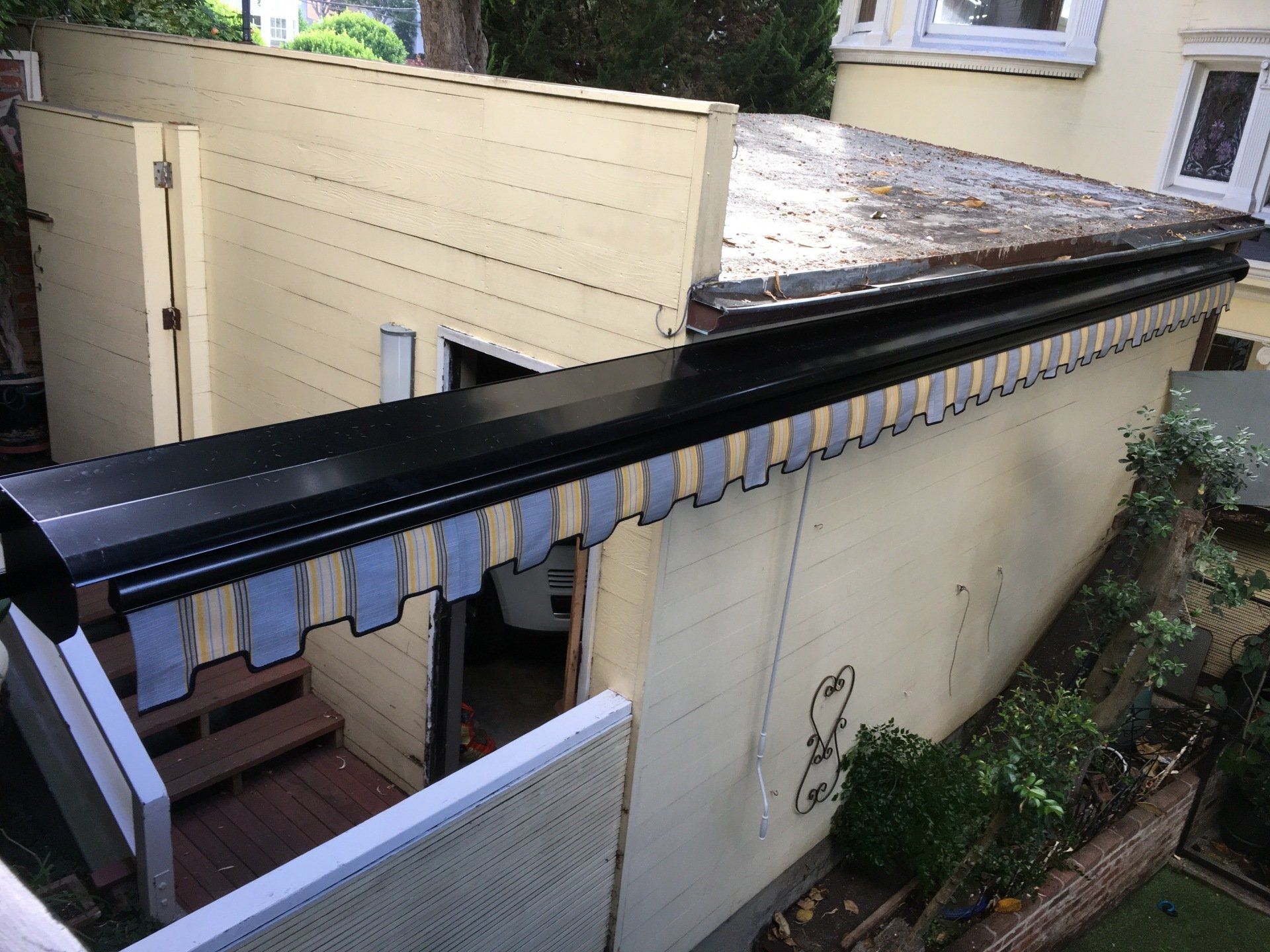 A house with a black awning on the side of it