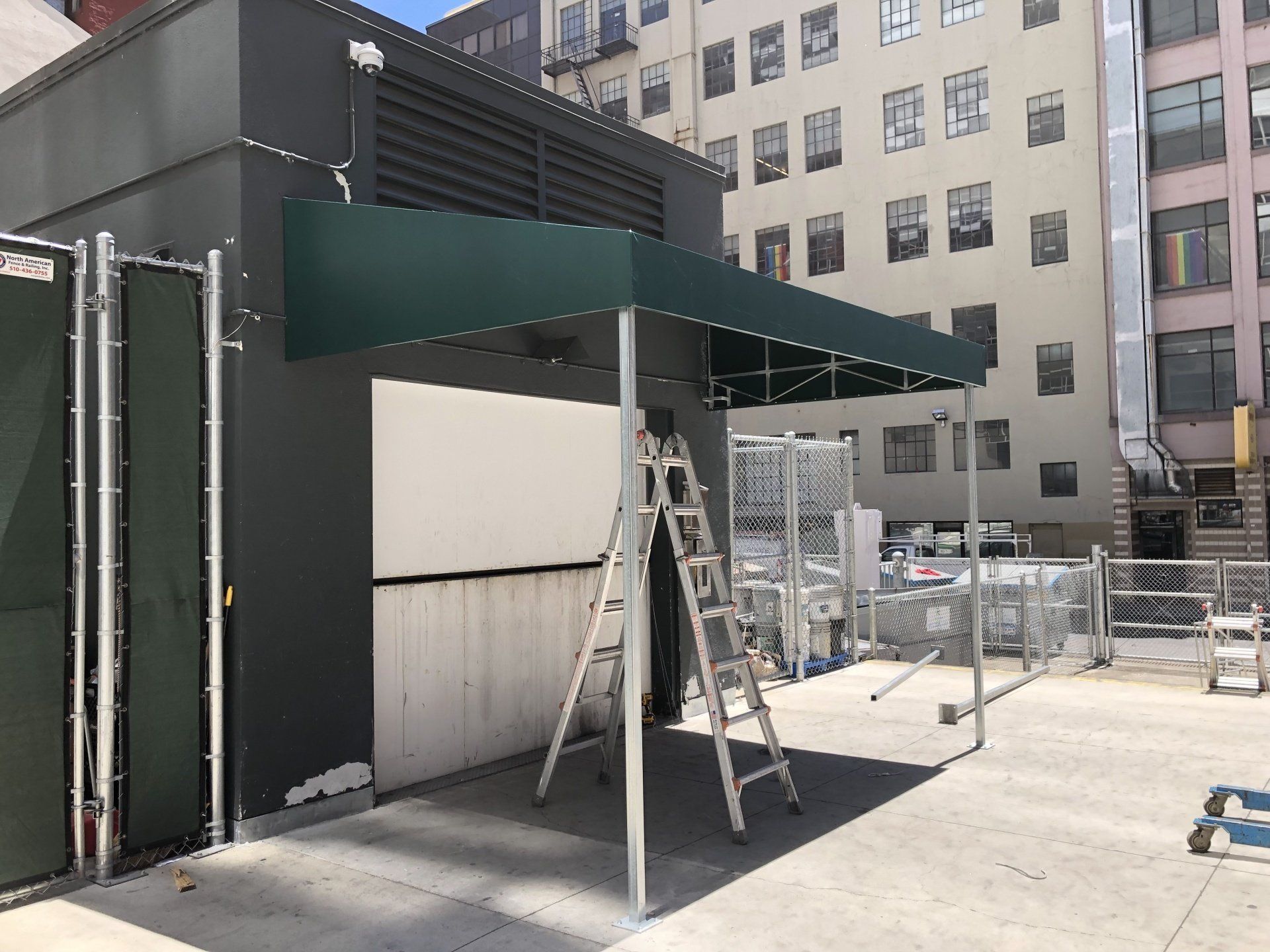 A green canopy is being built on the side of a building.
