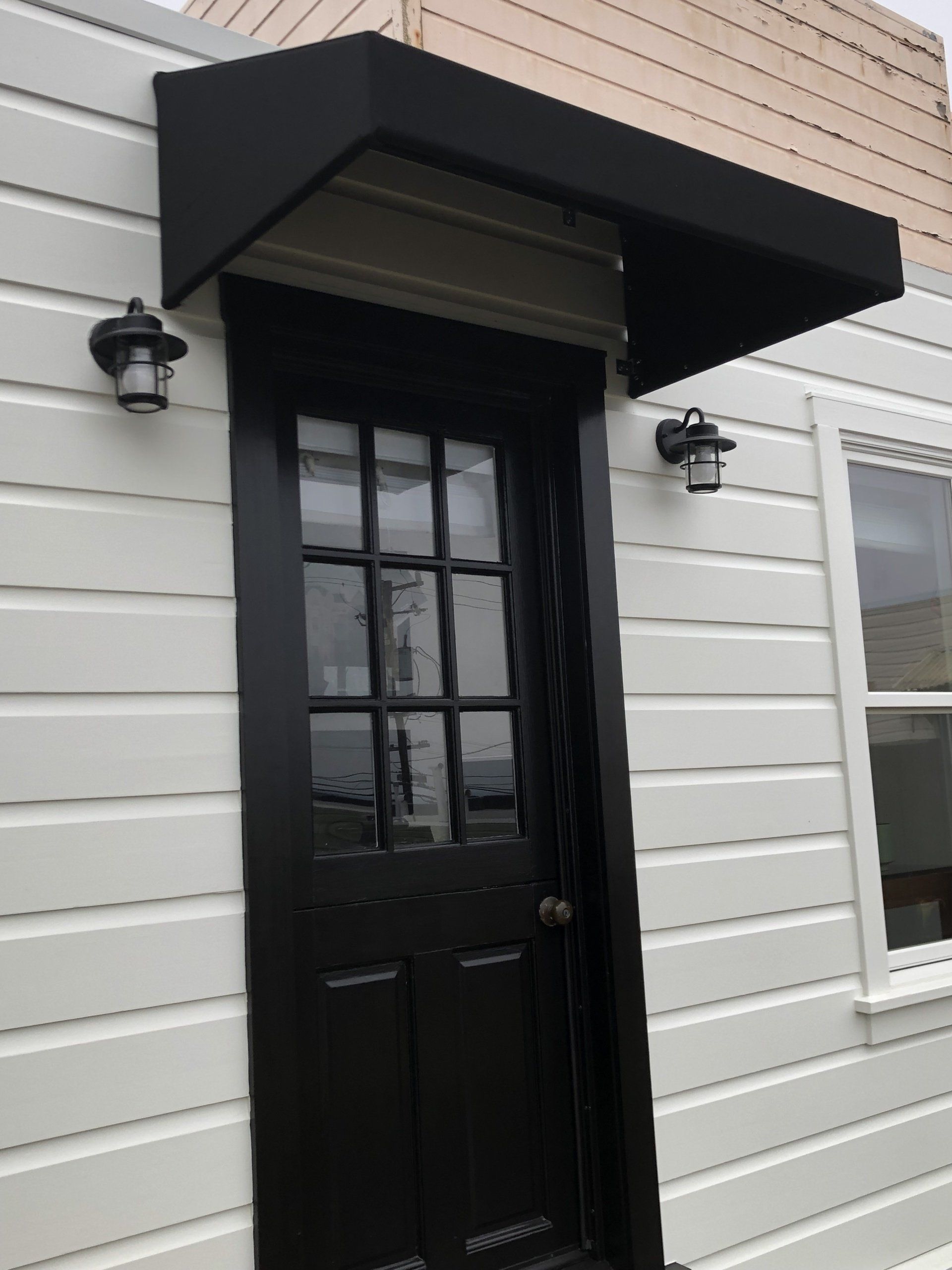 A black door with a black awning over it