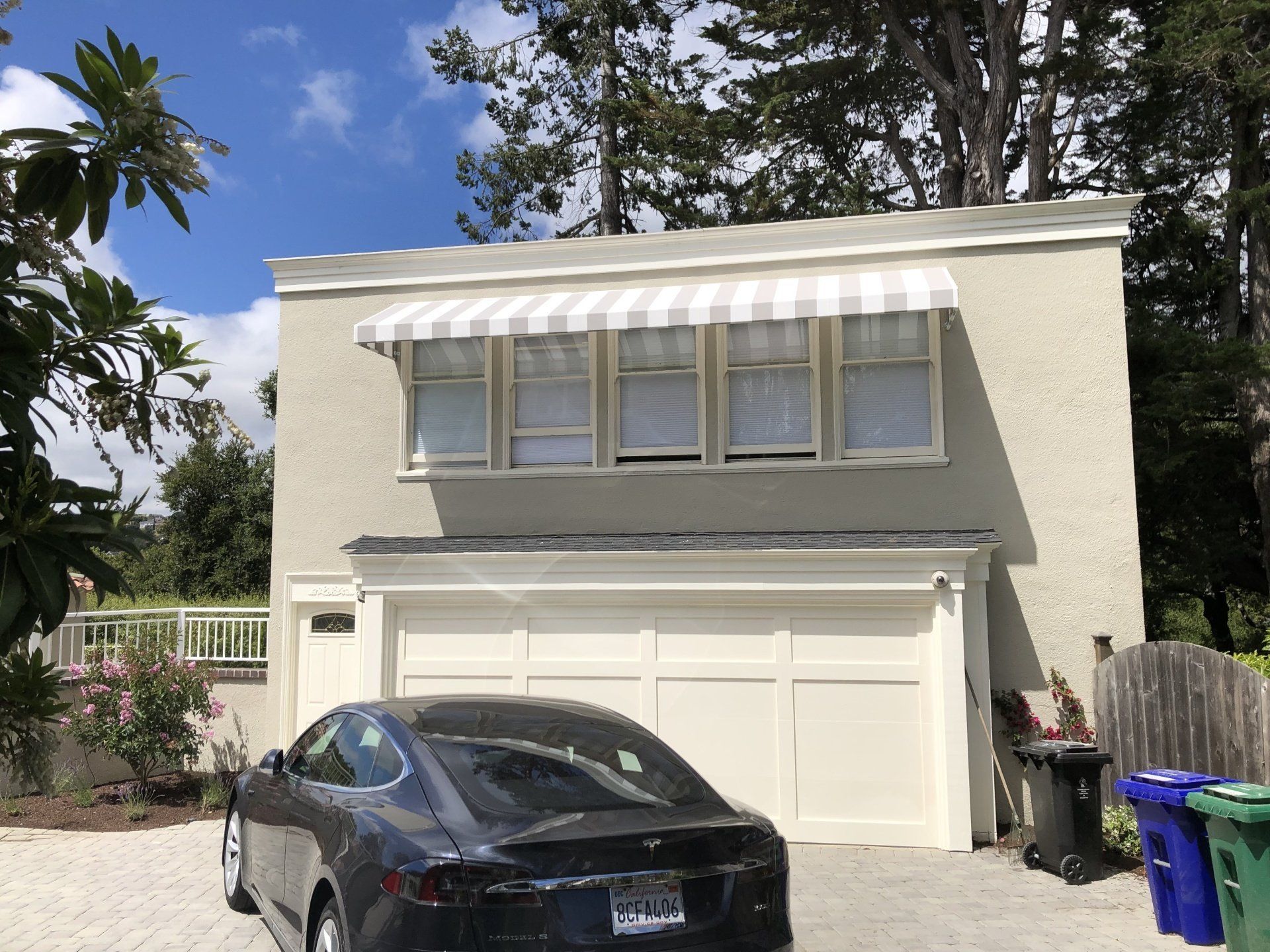 A tesla model s is parked in front of a garage