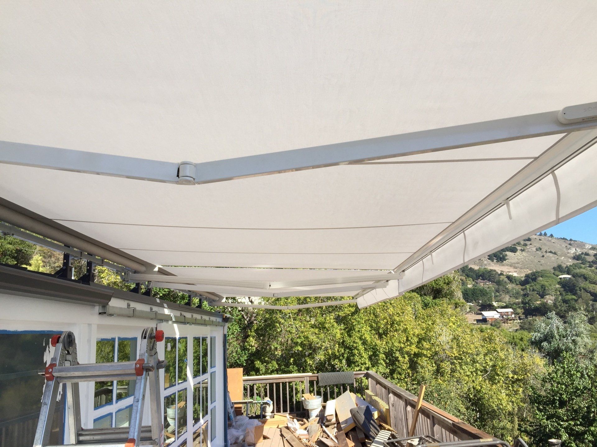 A white awning is hanging from the roof of a building.