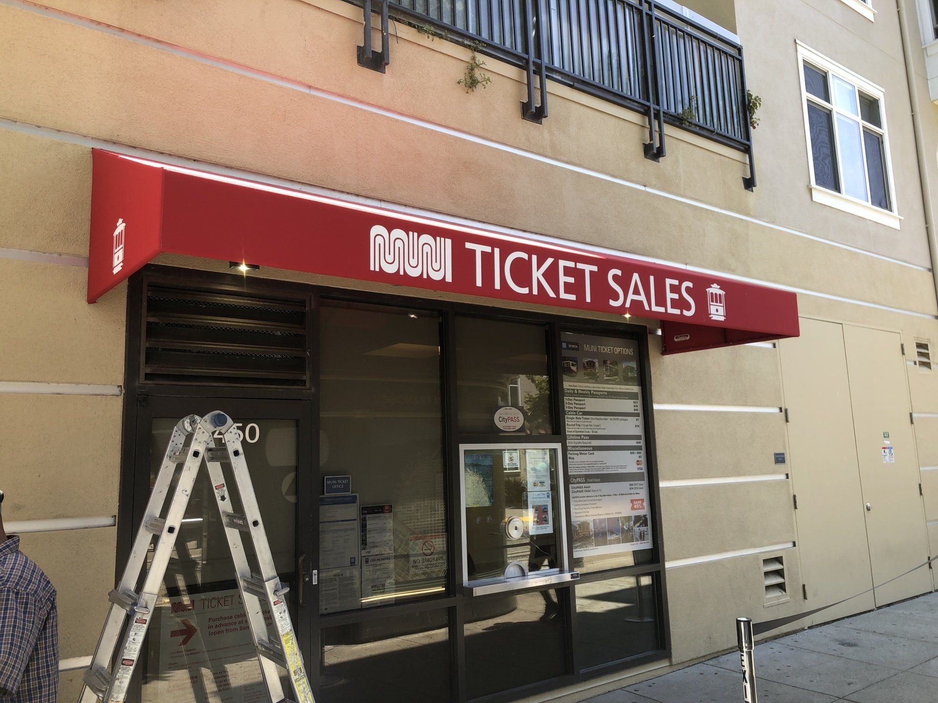 A red awning on the side of a building that says ticket sales
