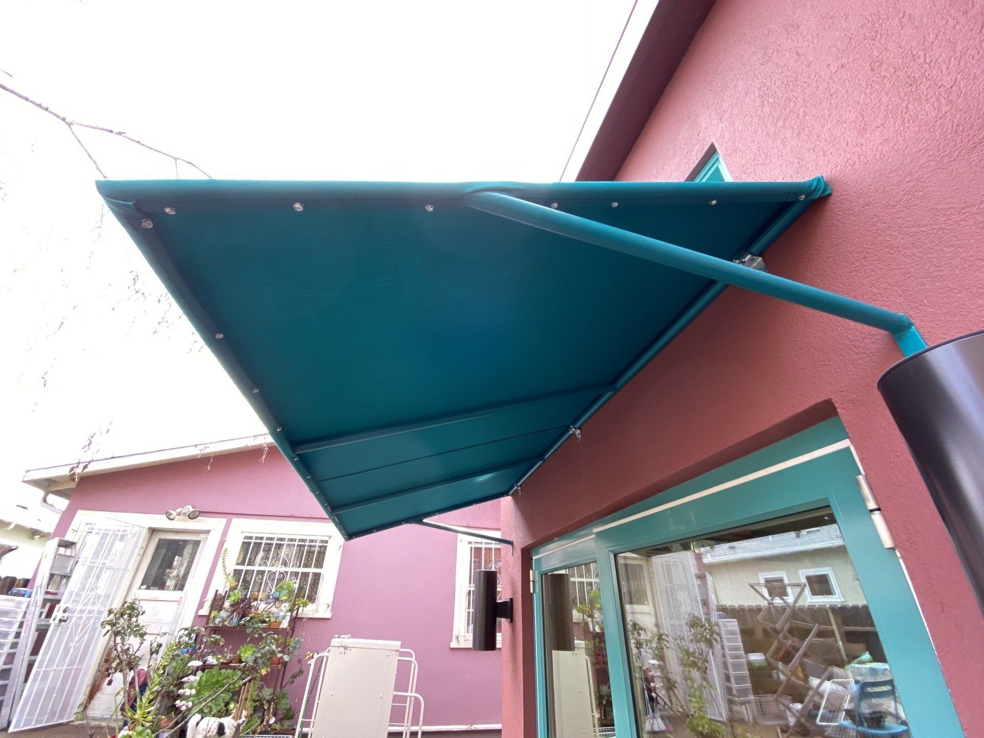 A pink building with a blue awning over a window