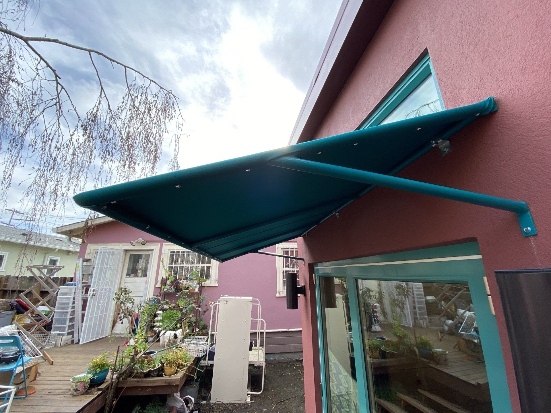 A pink building with a blue awning over the door