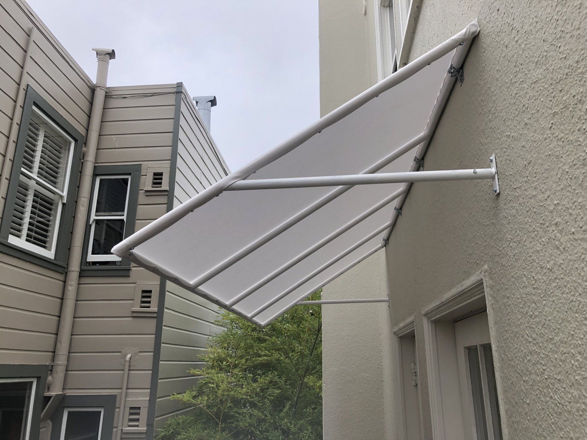 A white canopy is attached to the side of a building.