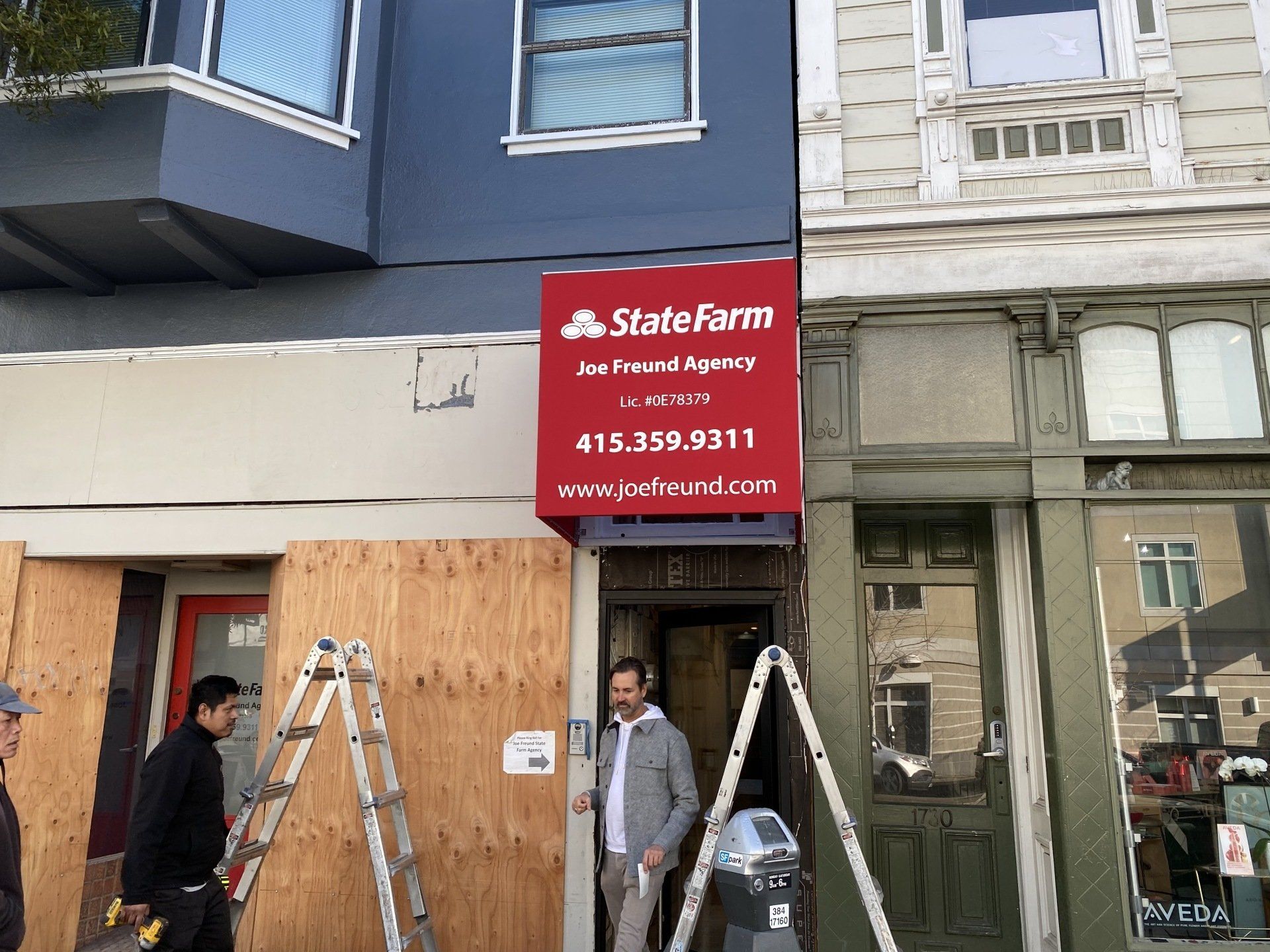 A man is standing in front of a building with a sign that says state farms on it.