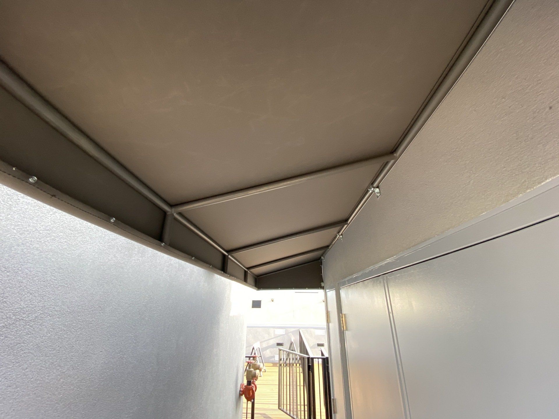 A person is walking down a hallway with a canopy over it.