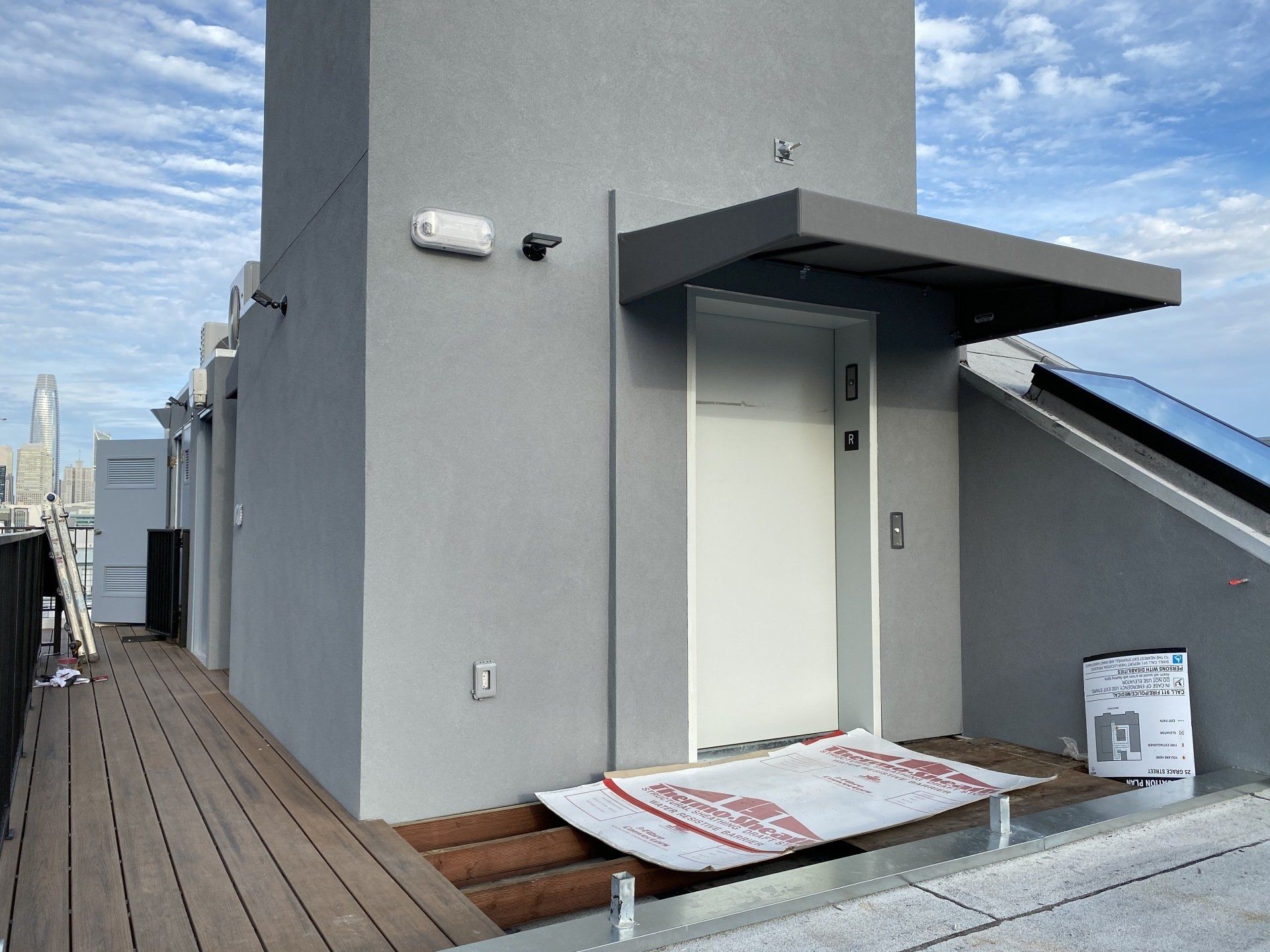 A gray building with a white door and a canopy