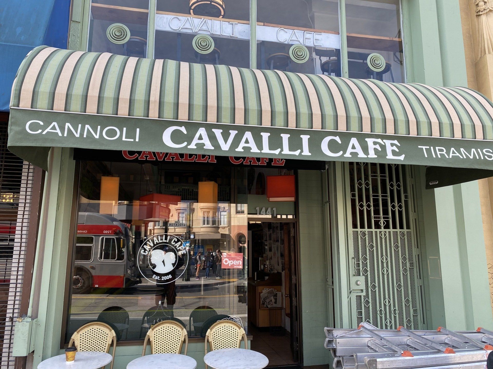 The cannoli cavalli cafe has a striped awning over it