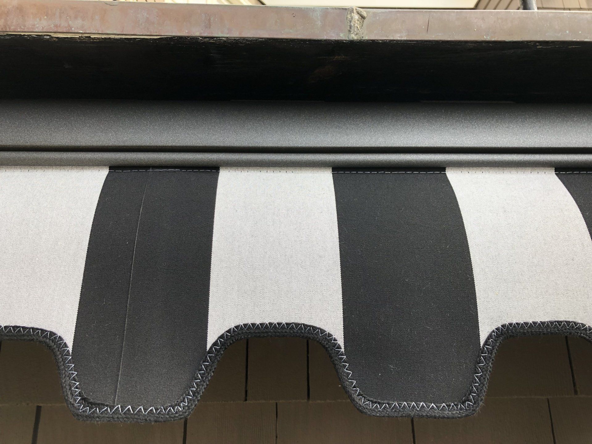 A black and white striped awning is hanging over a window.