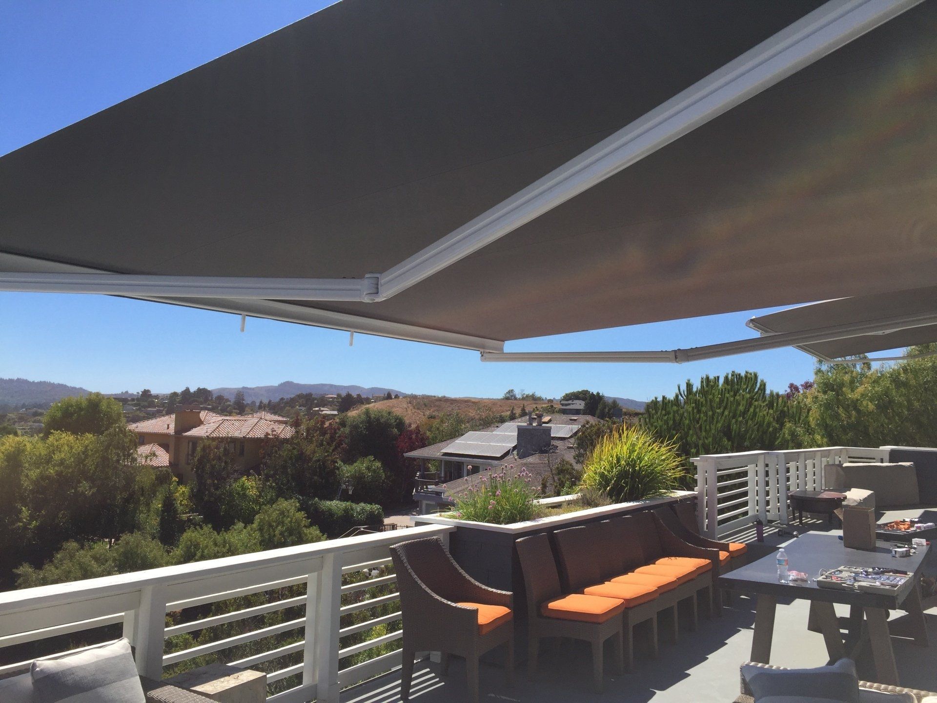 A balcony with a table and chairs under an awning