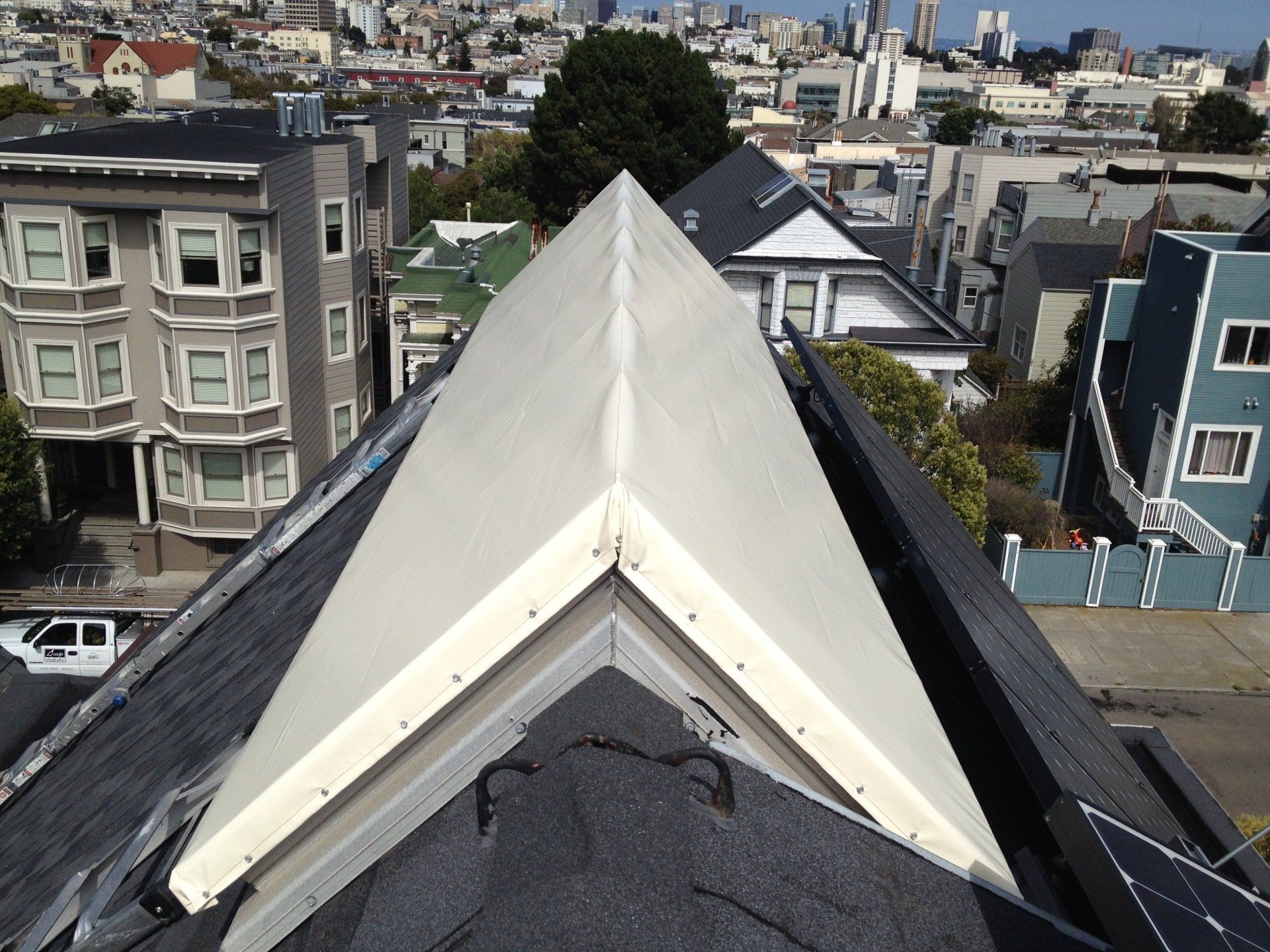 An aerial view of a city with a roof in the foreground
