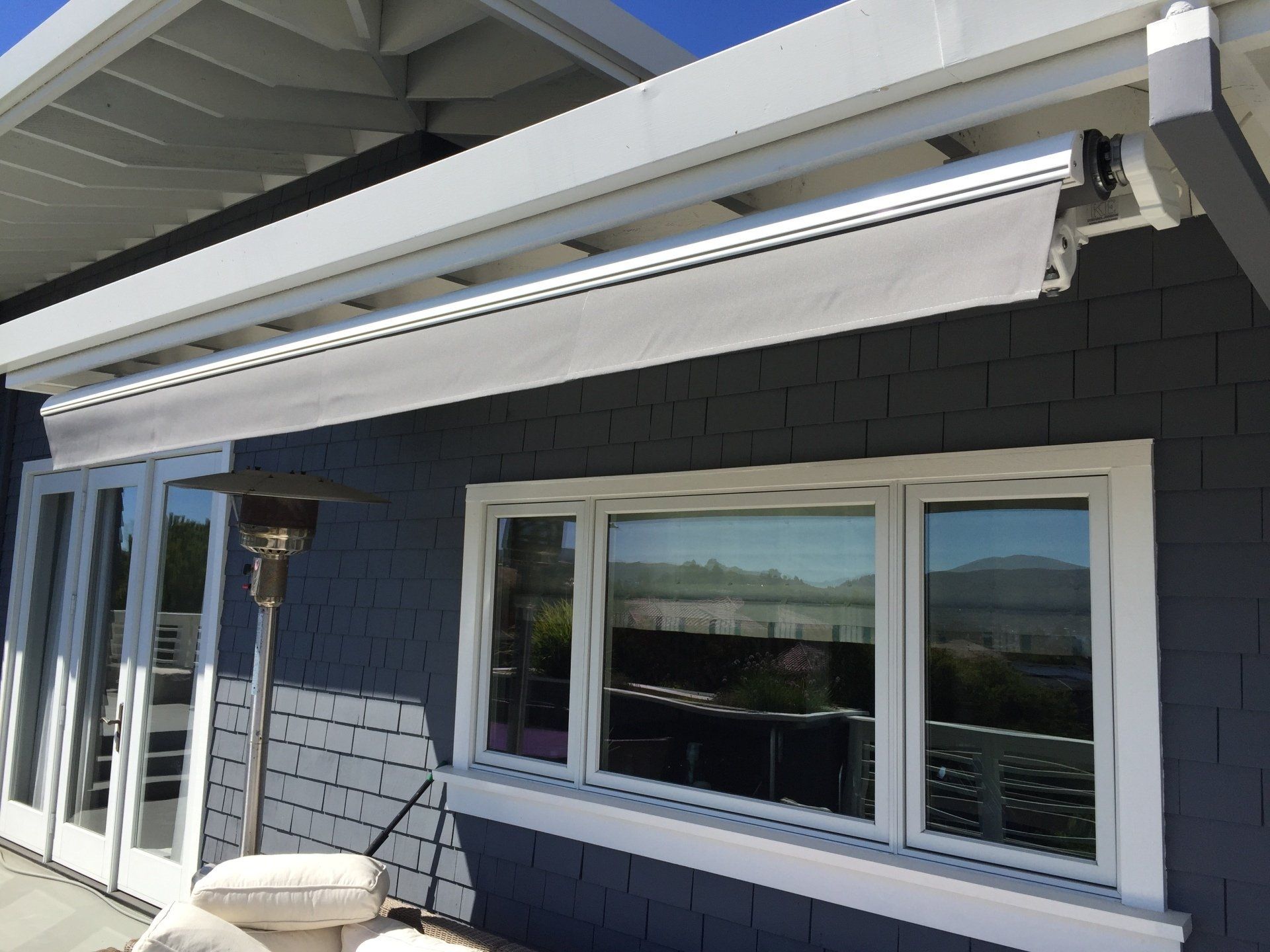 A blue house with a white awning over the windows