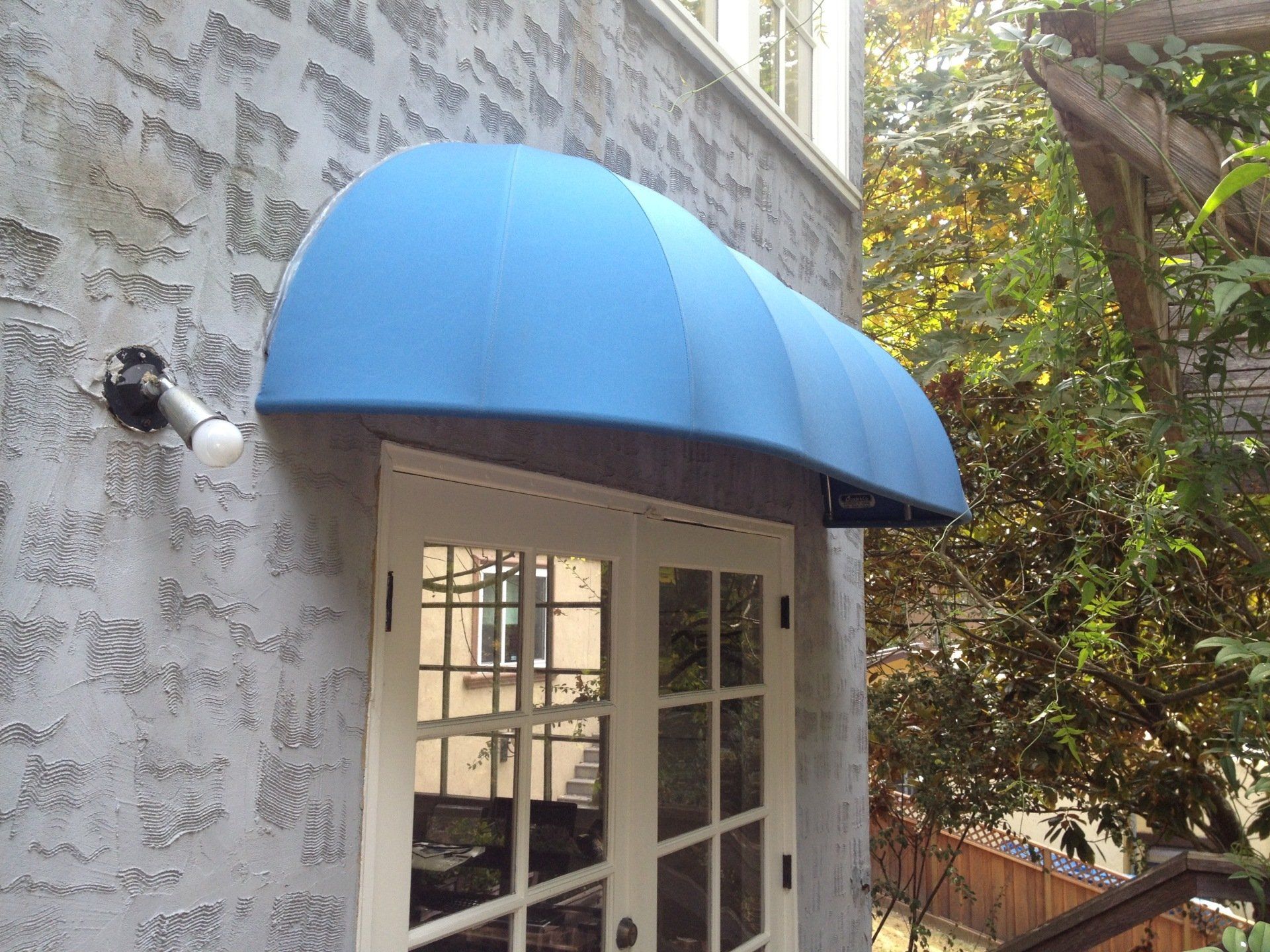 A blue awning is on the side of a building