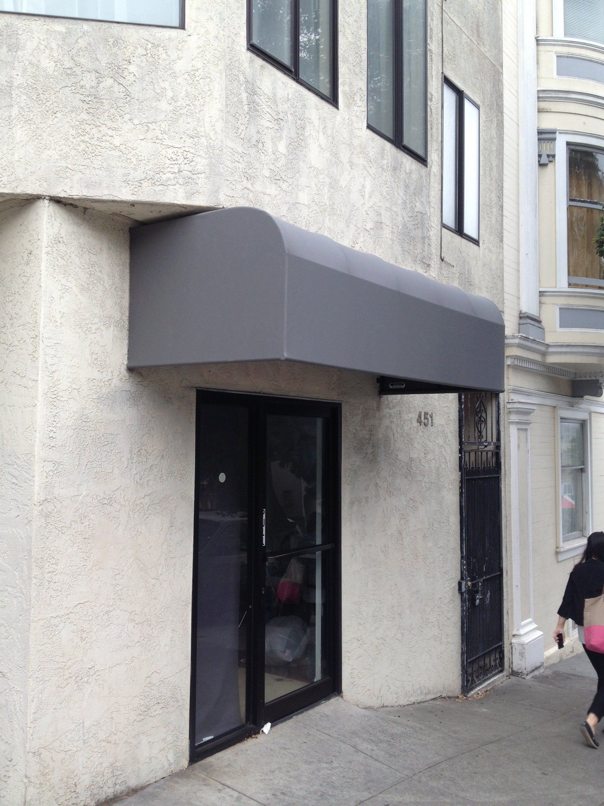 A building with a gray awning over the door