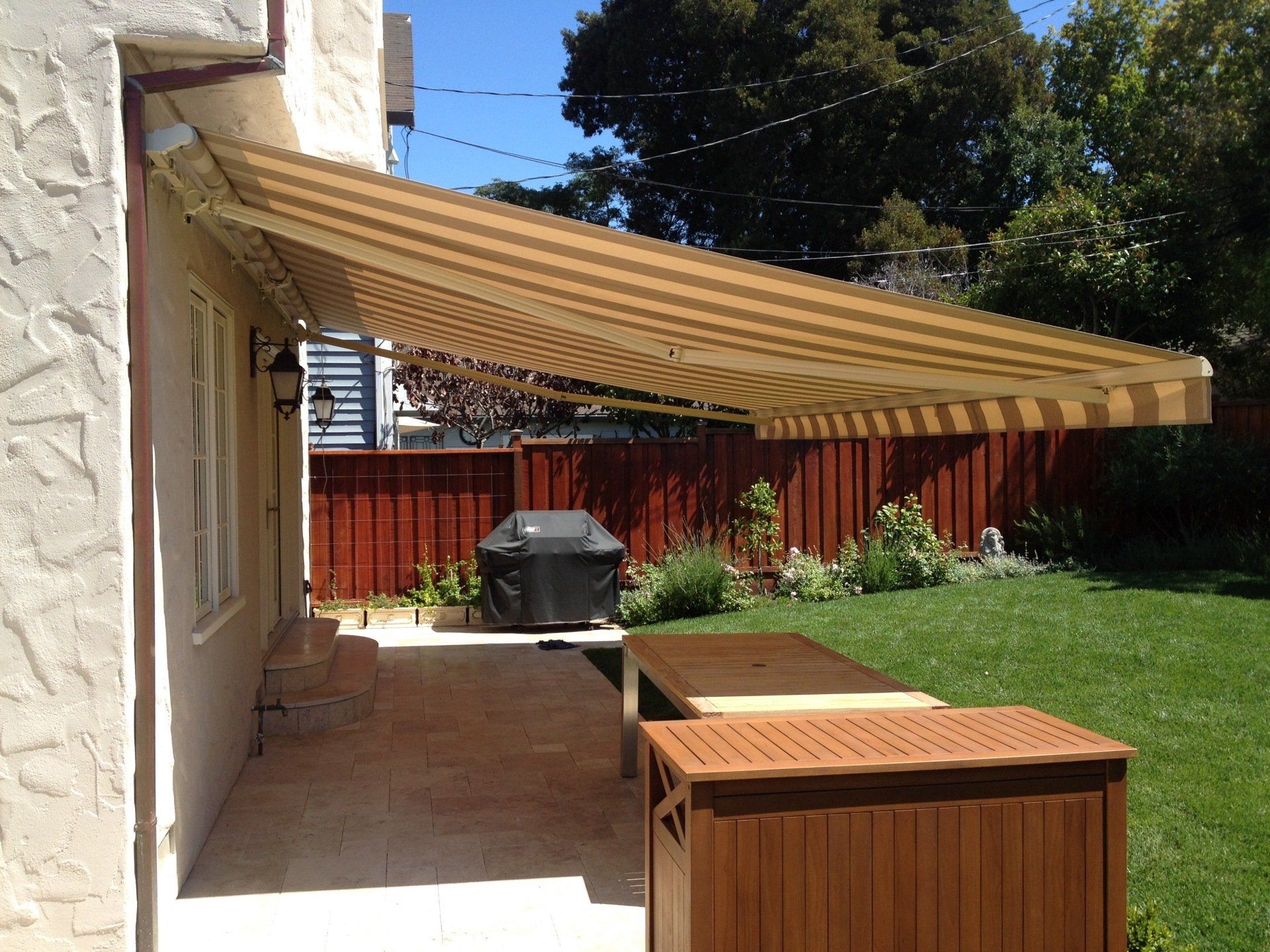 A patio with a striped awning over it