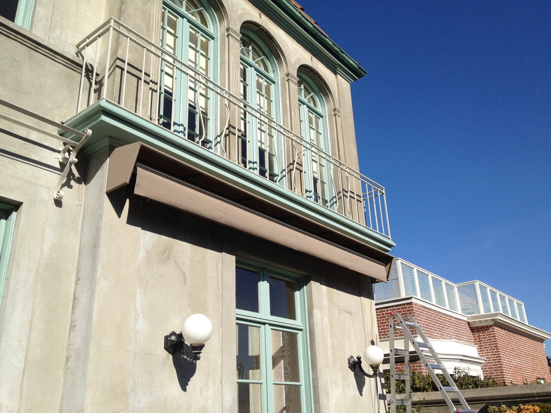 A balcony on the side of a building with a blue sky in the background