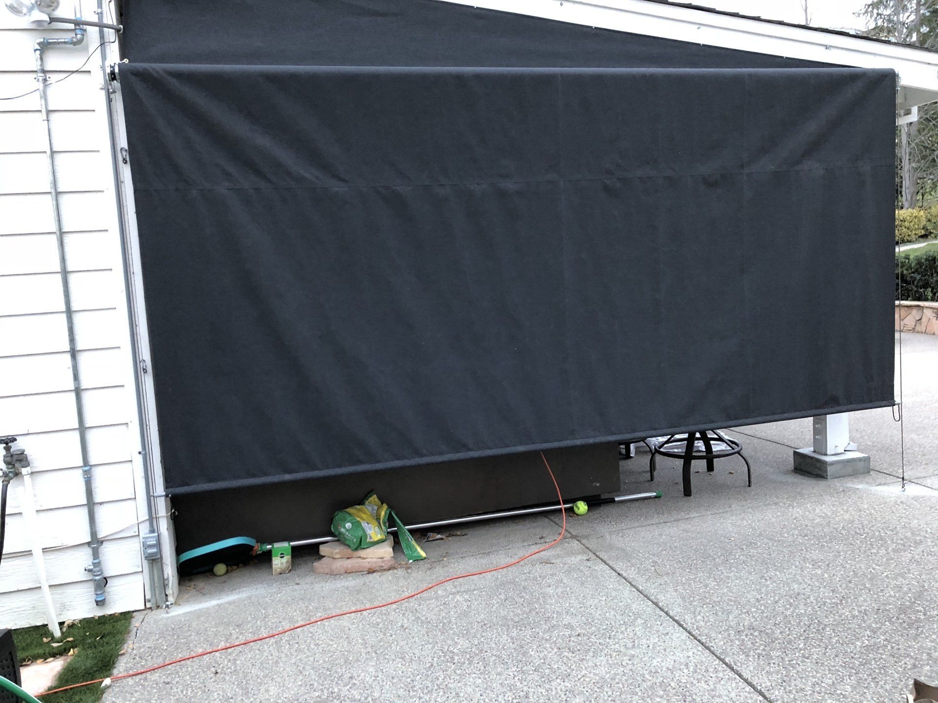 A black awning is covering the side of a garage door.