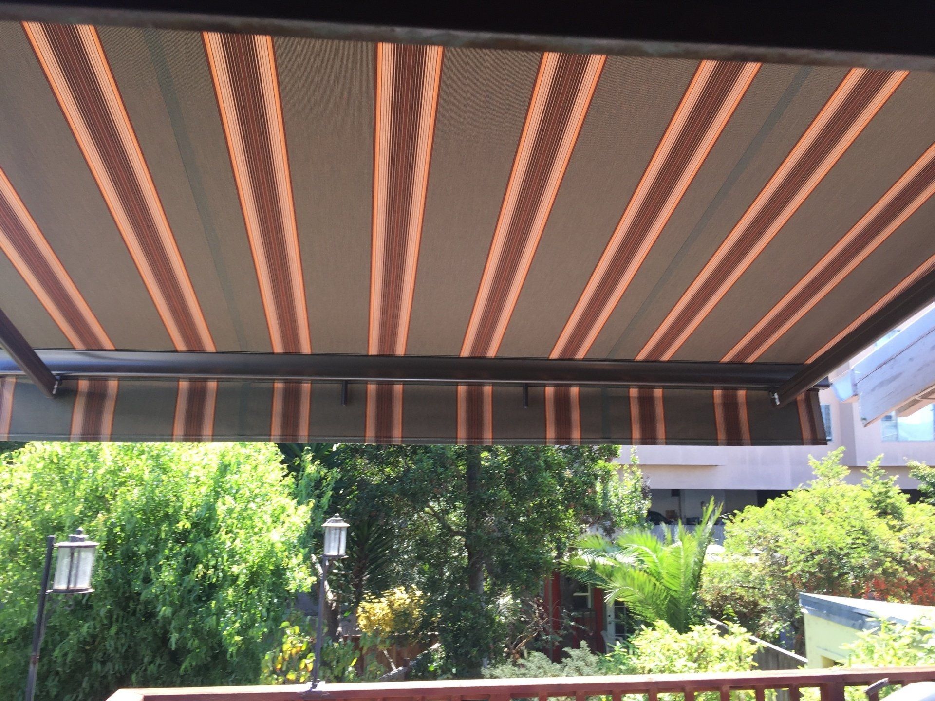 A balcony with a striped awning over it