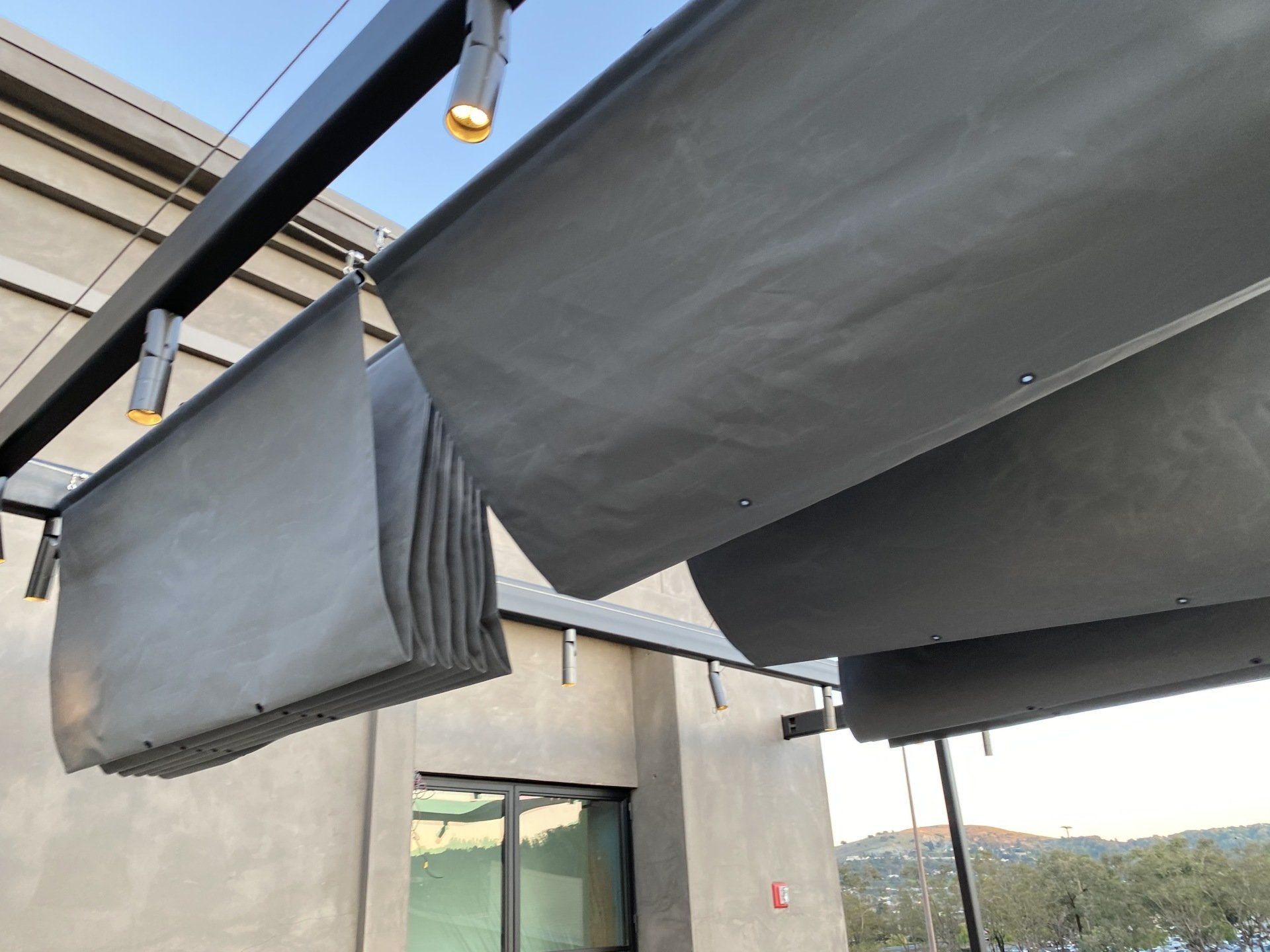 A gray awning is hanging from the roof of a building