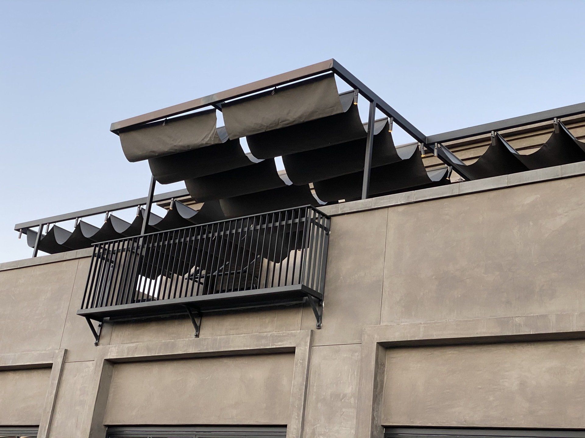 A balcony on the side of a building with a canopy over it