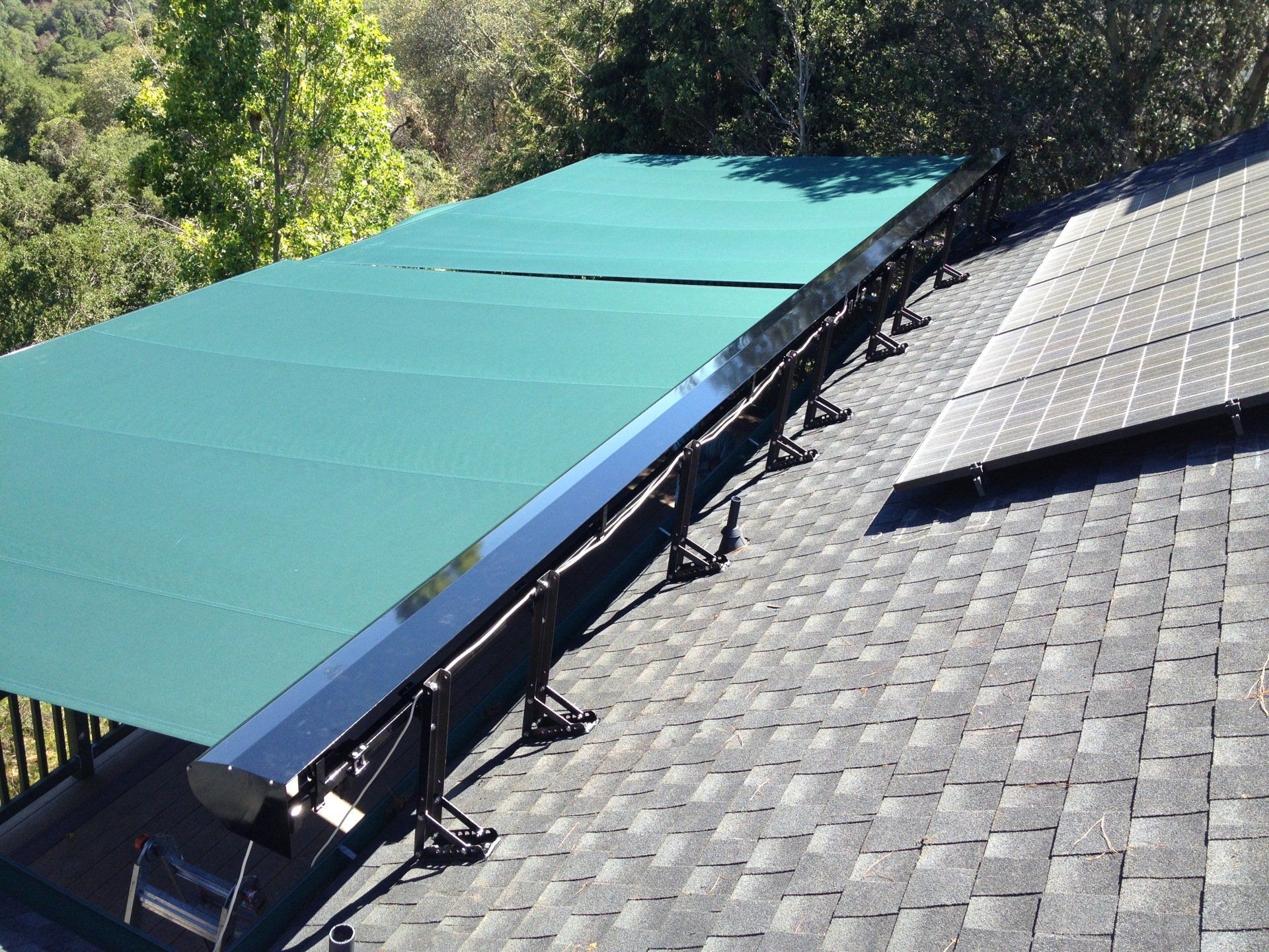 A roof with a green awning and solar panels on it