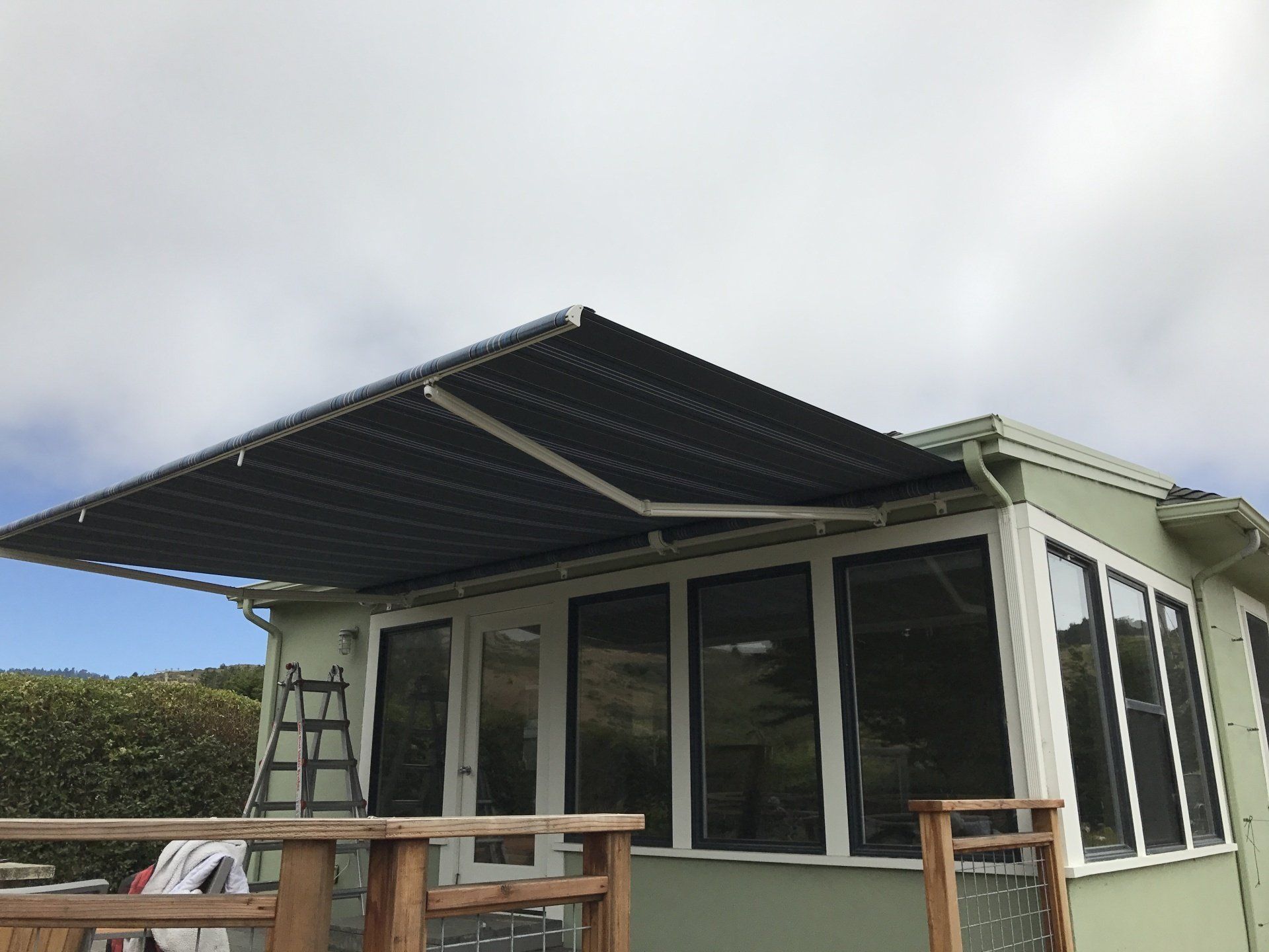 A green house with a black awning on the roof.