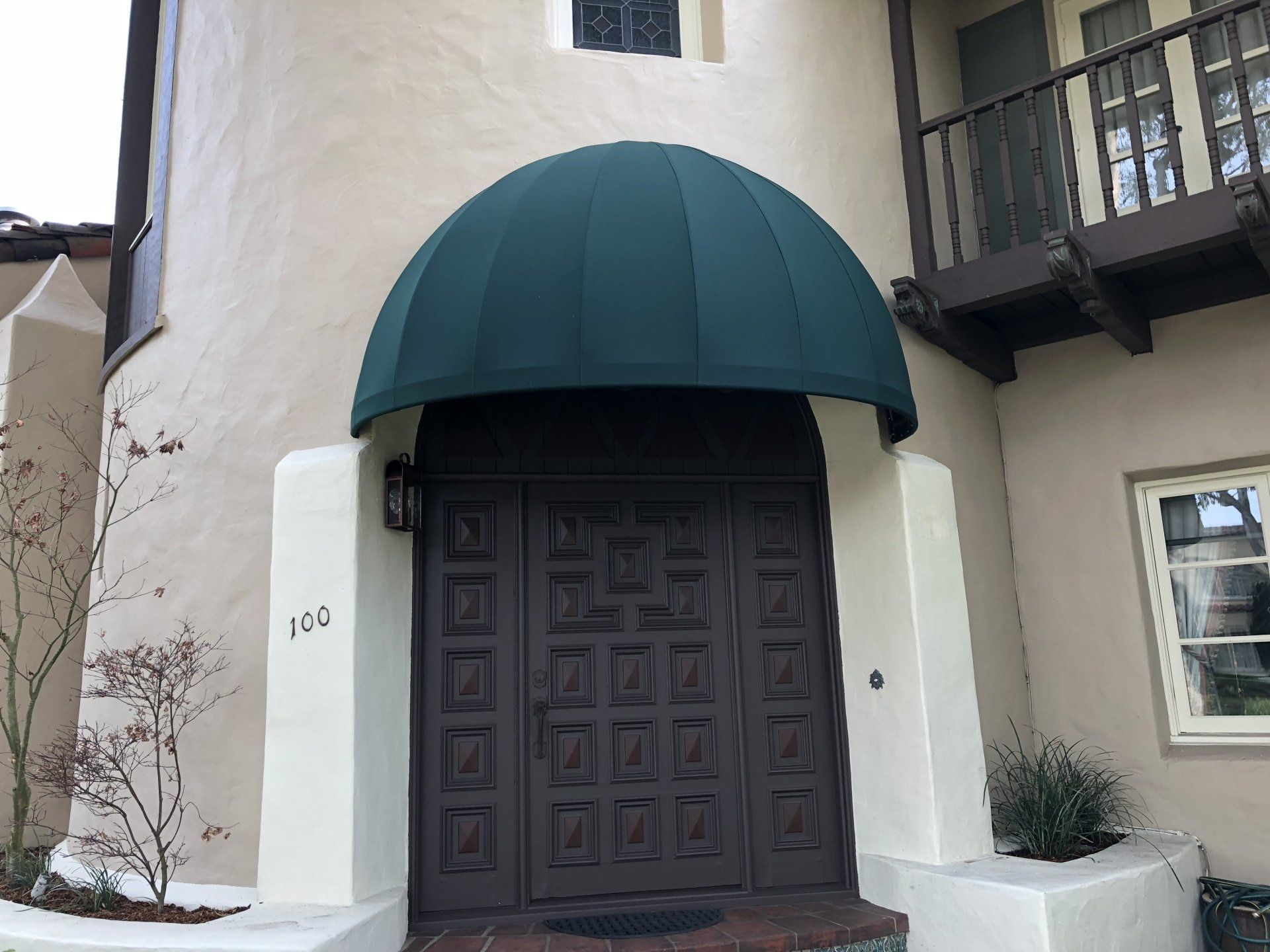 The front door of a building with a green awning over it.