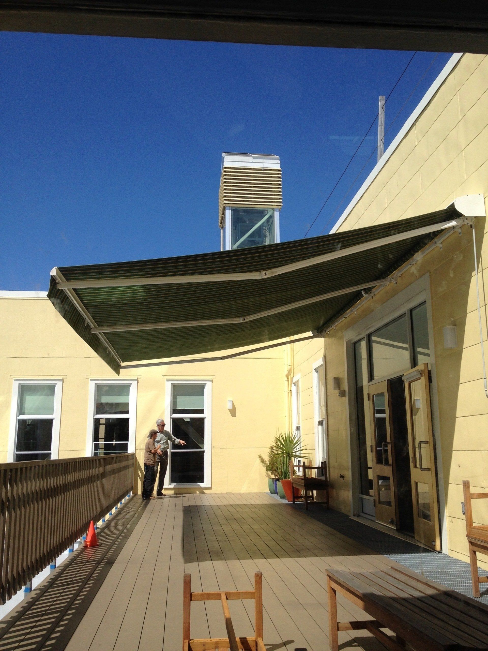 A yellow building with a green awning on the side