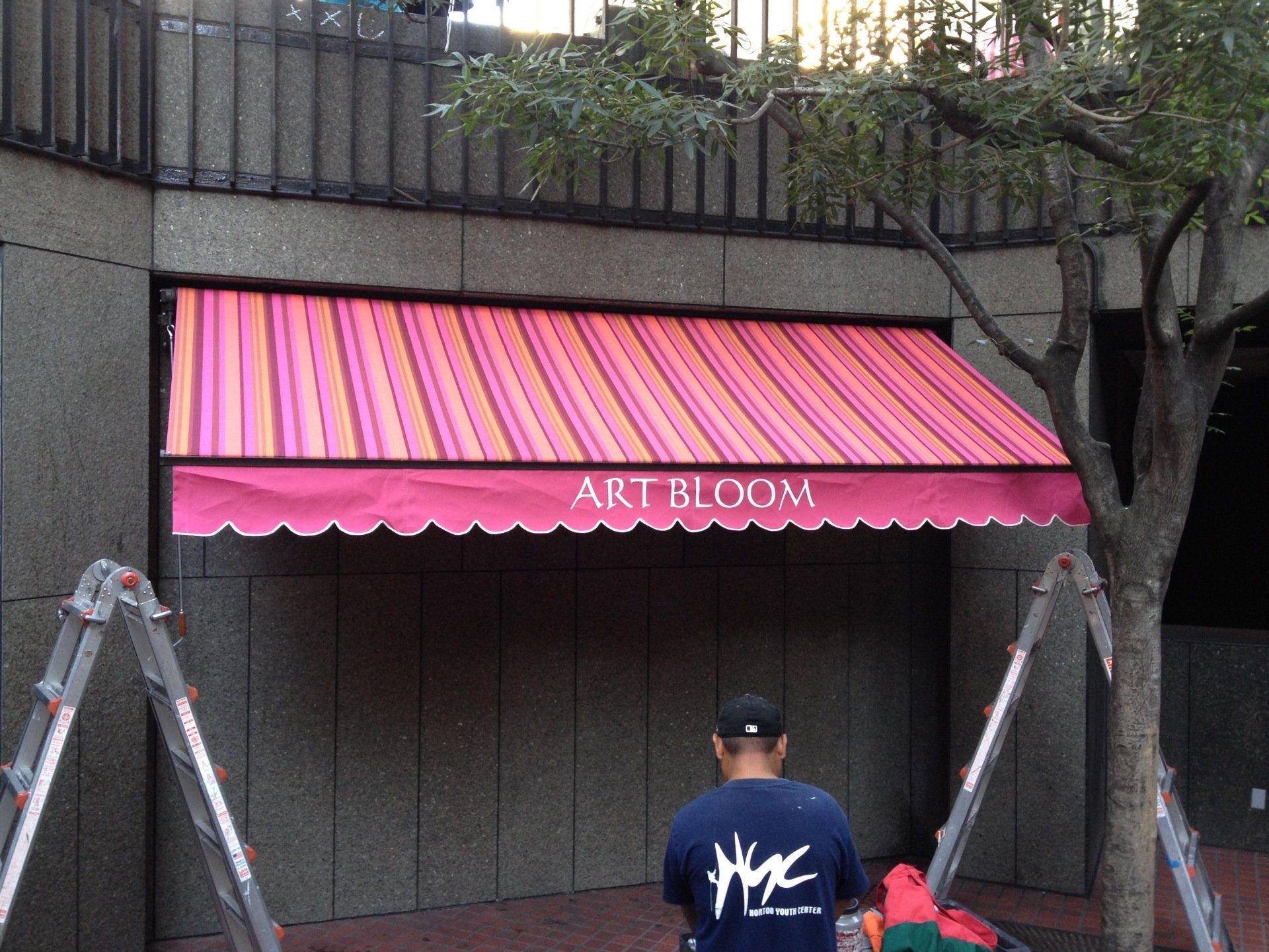 A man standing under an awning that says art bloom