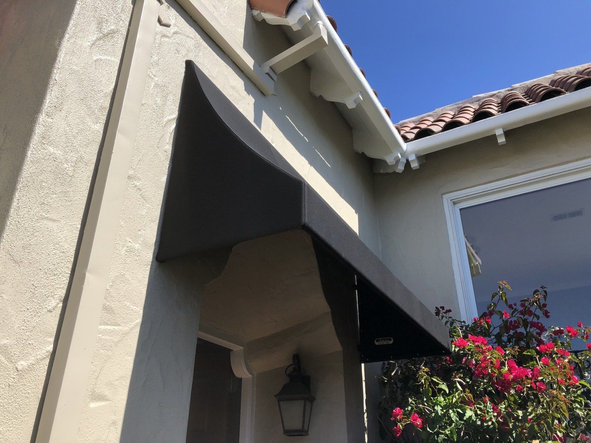 A house with a gutter on the side of it and a lantern on the porch.