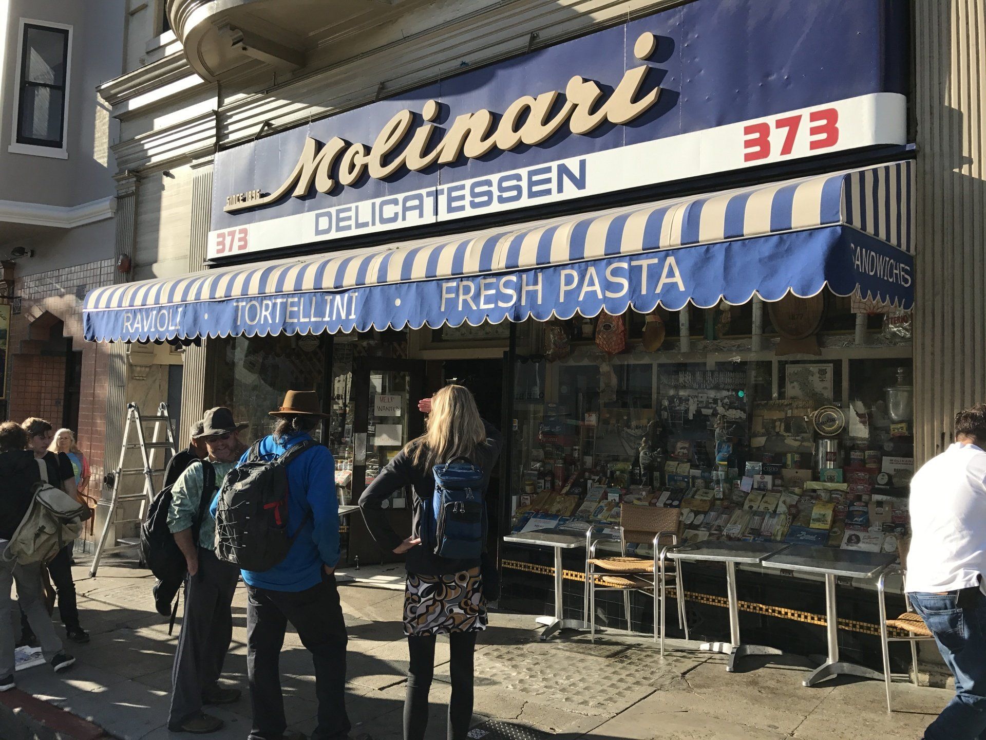 A group of people are standing outside of a store called molinari