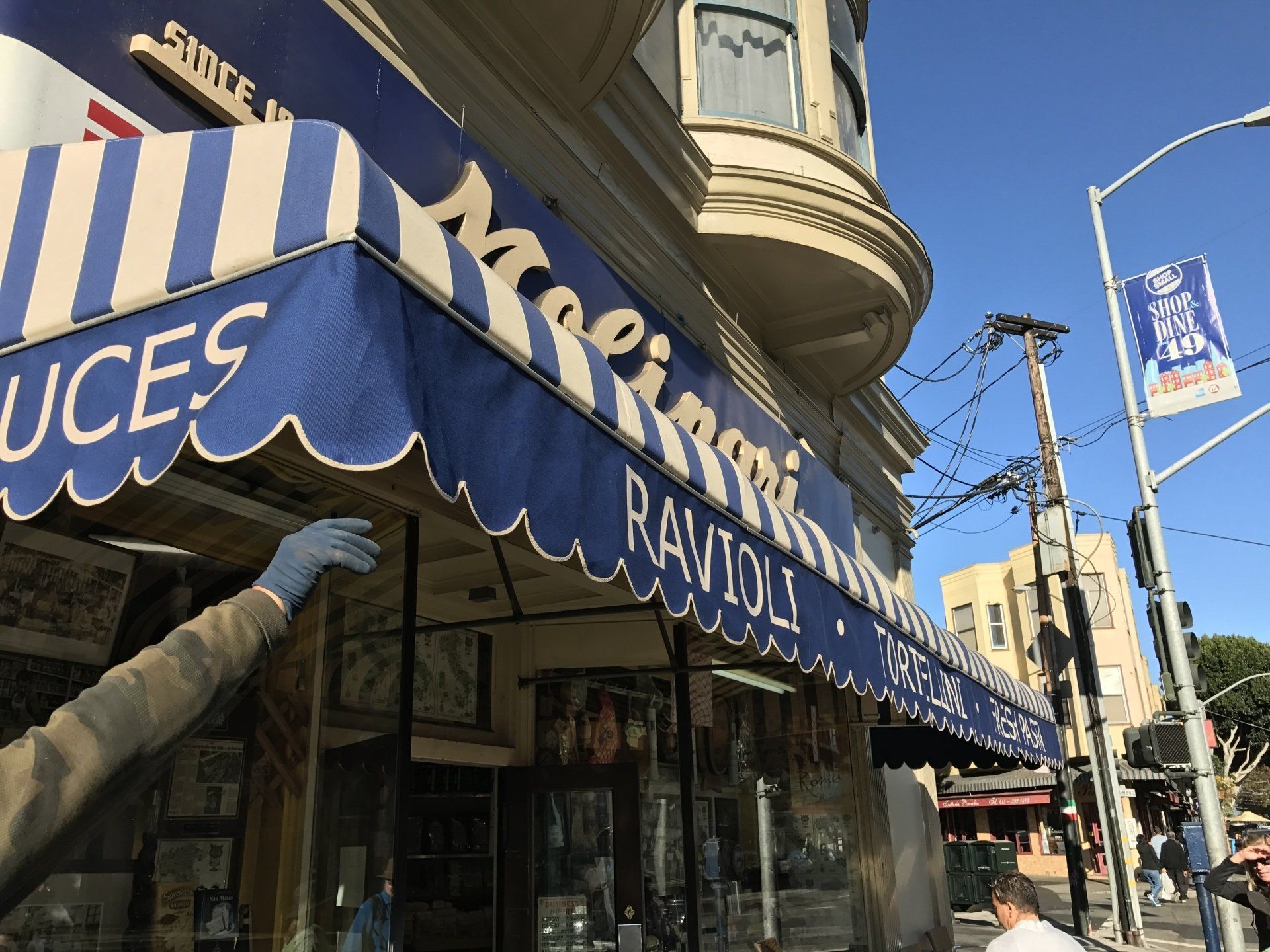A store front with a blue awning that says ravioli