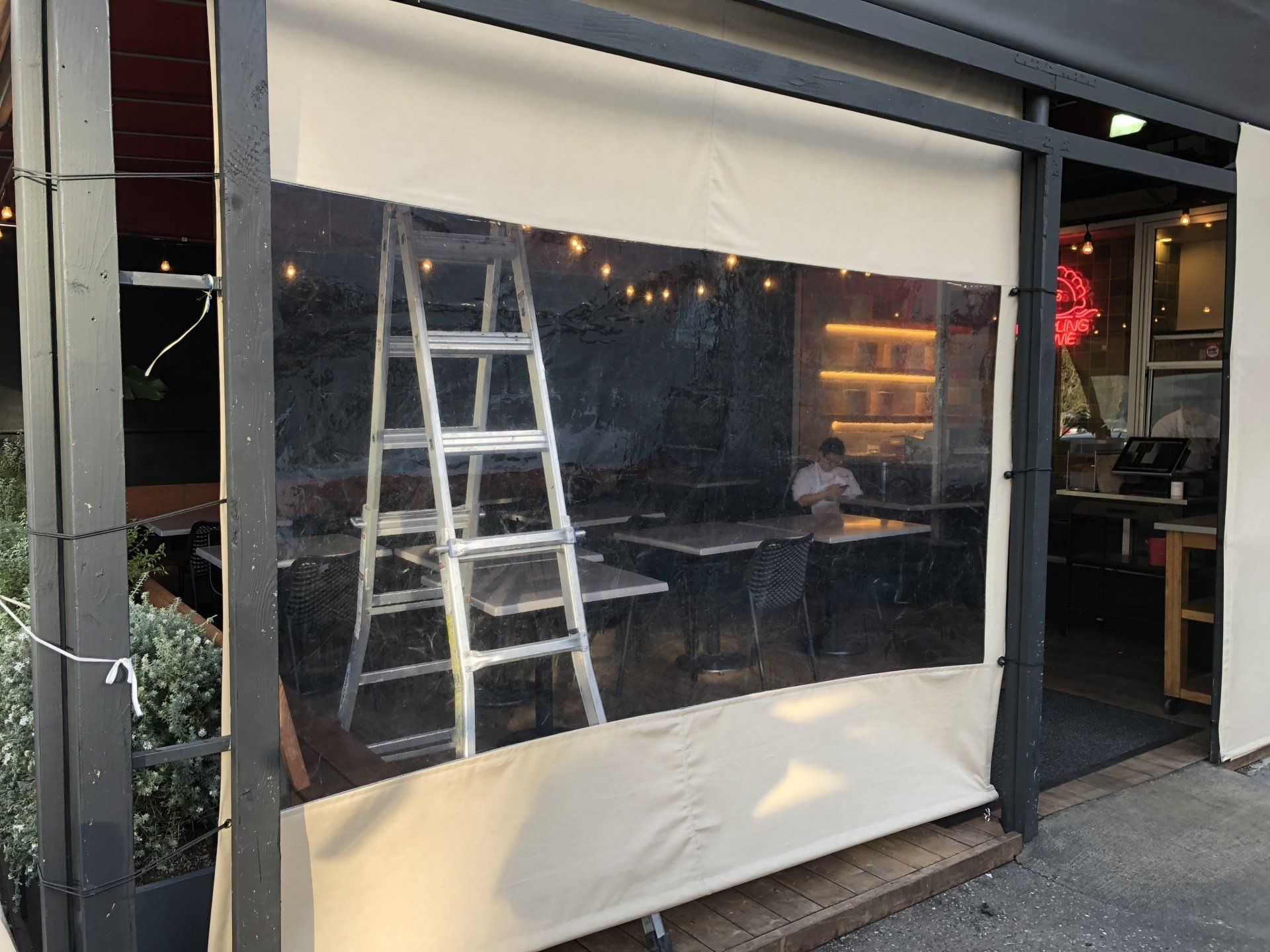 A ladder is sitting on the side of a building next to a window.