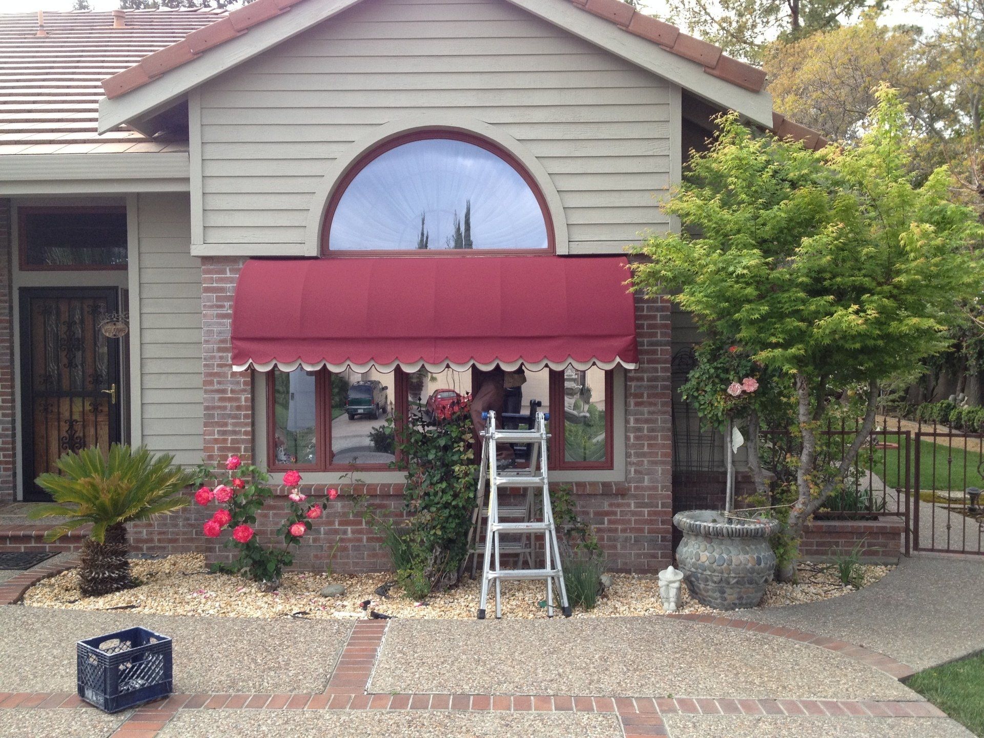 A house with a red awning and a ladder in front of it