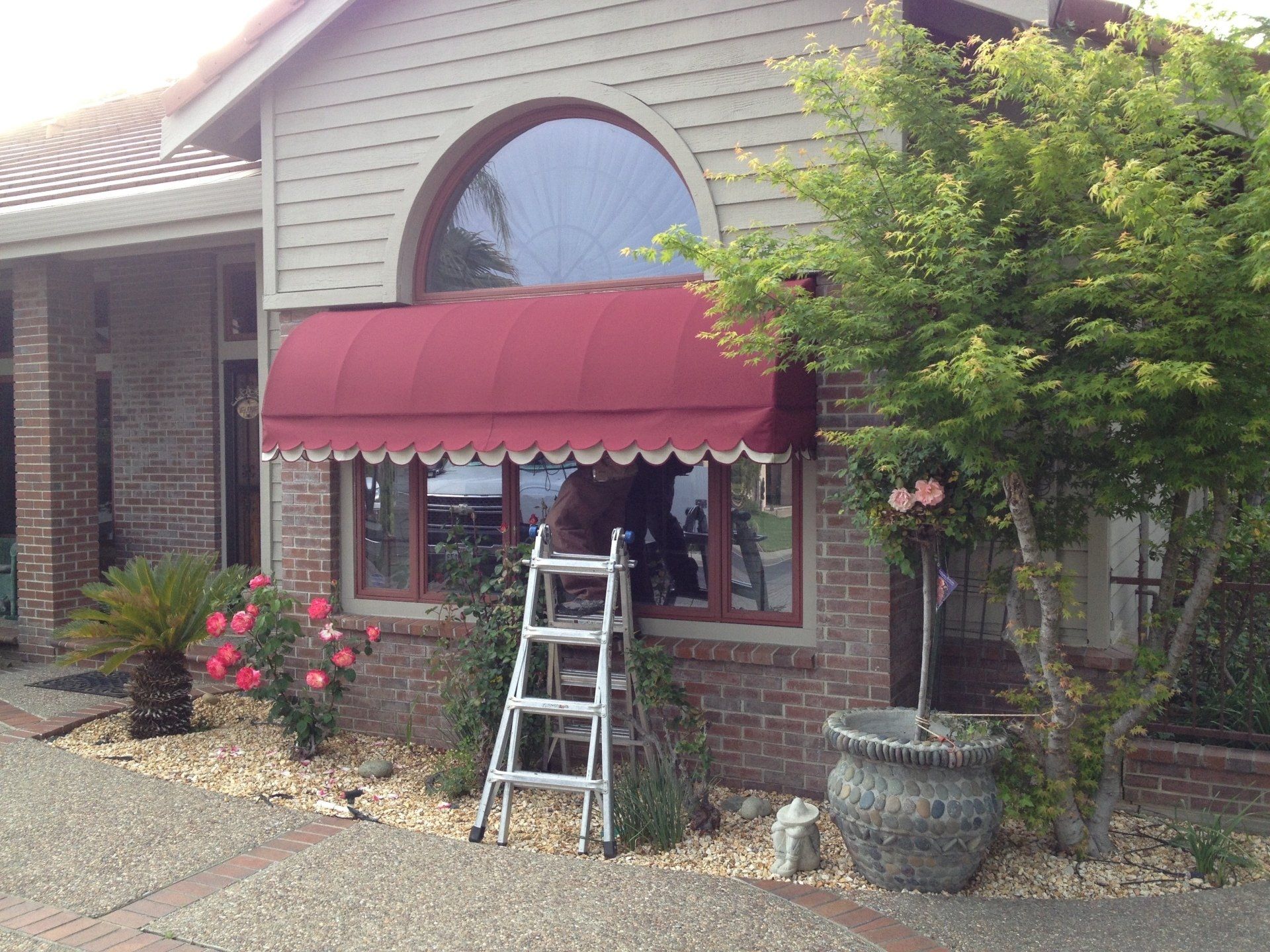 A house with a red awning and a ladder in front of it