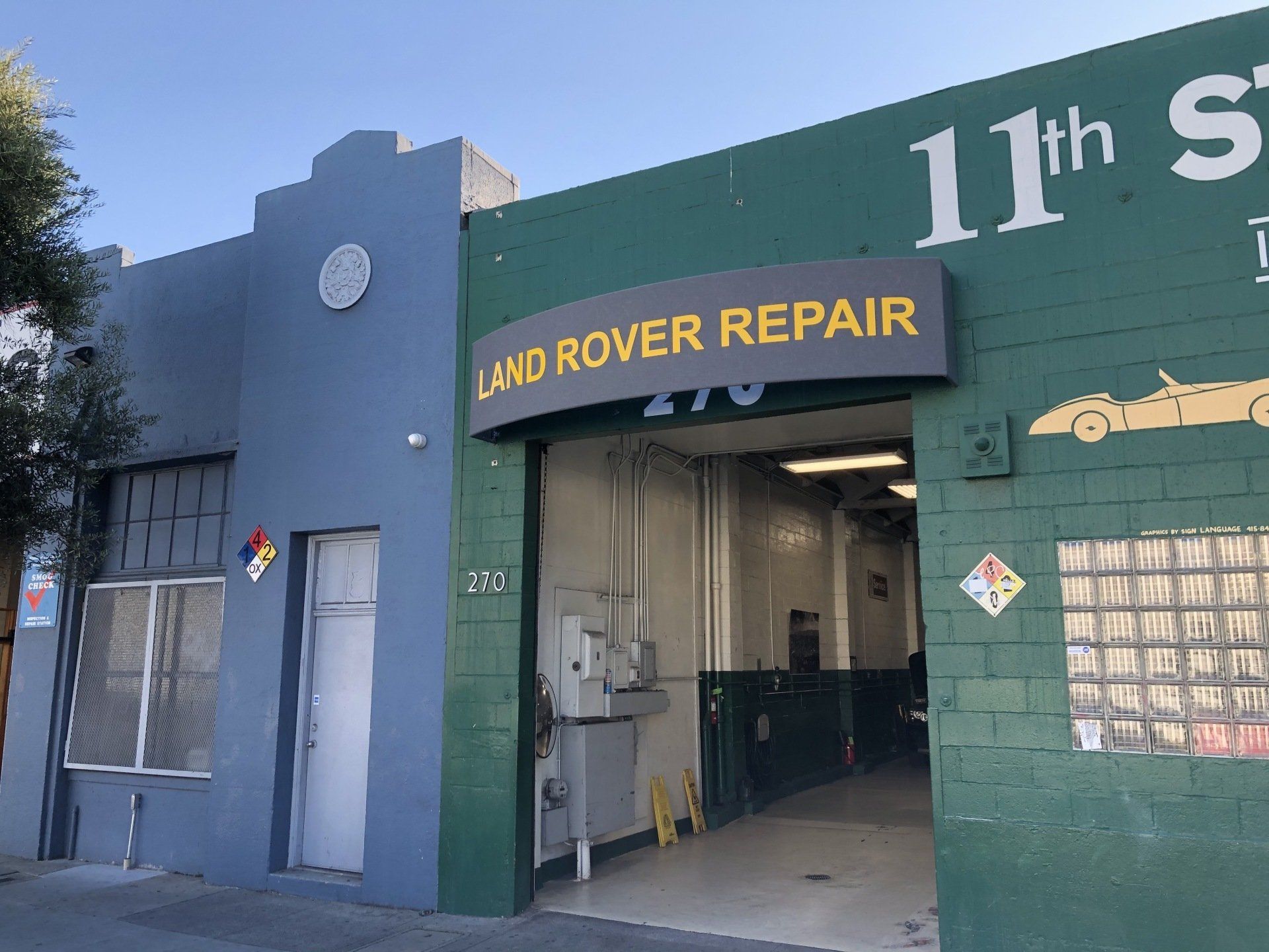 A green building with a sign that says land rover repair